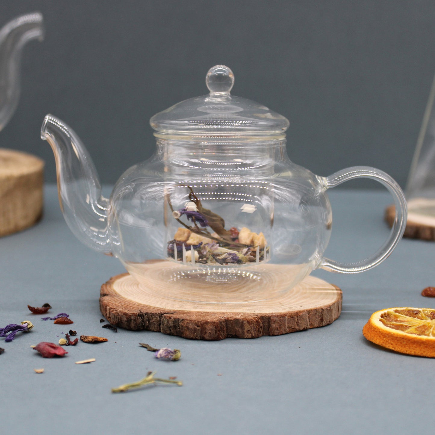 400ml Glass Round Pearl Infuser Teapot Sitting on a Chopping Board with Loose Tea in Strainer