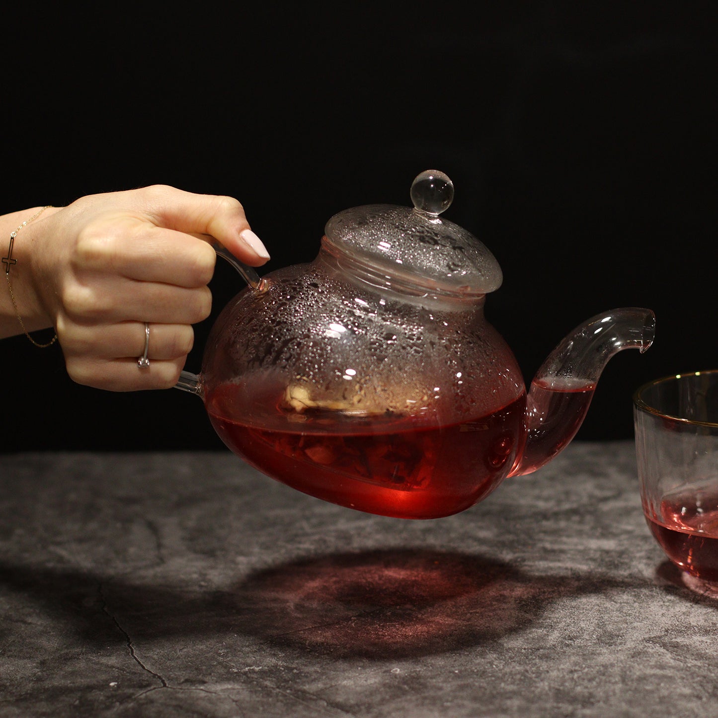 800ml Glass Round Pearl Infuser Teapot Pouring Tea into a Teacup