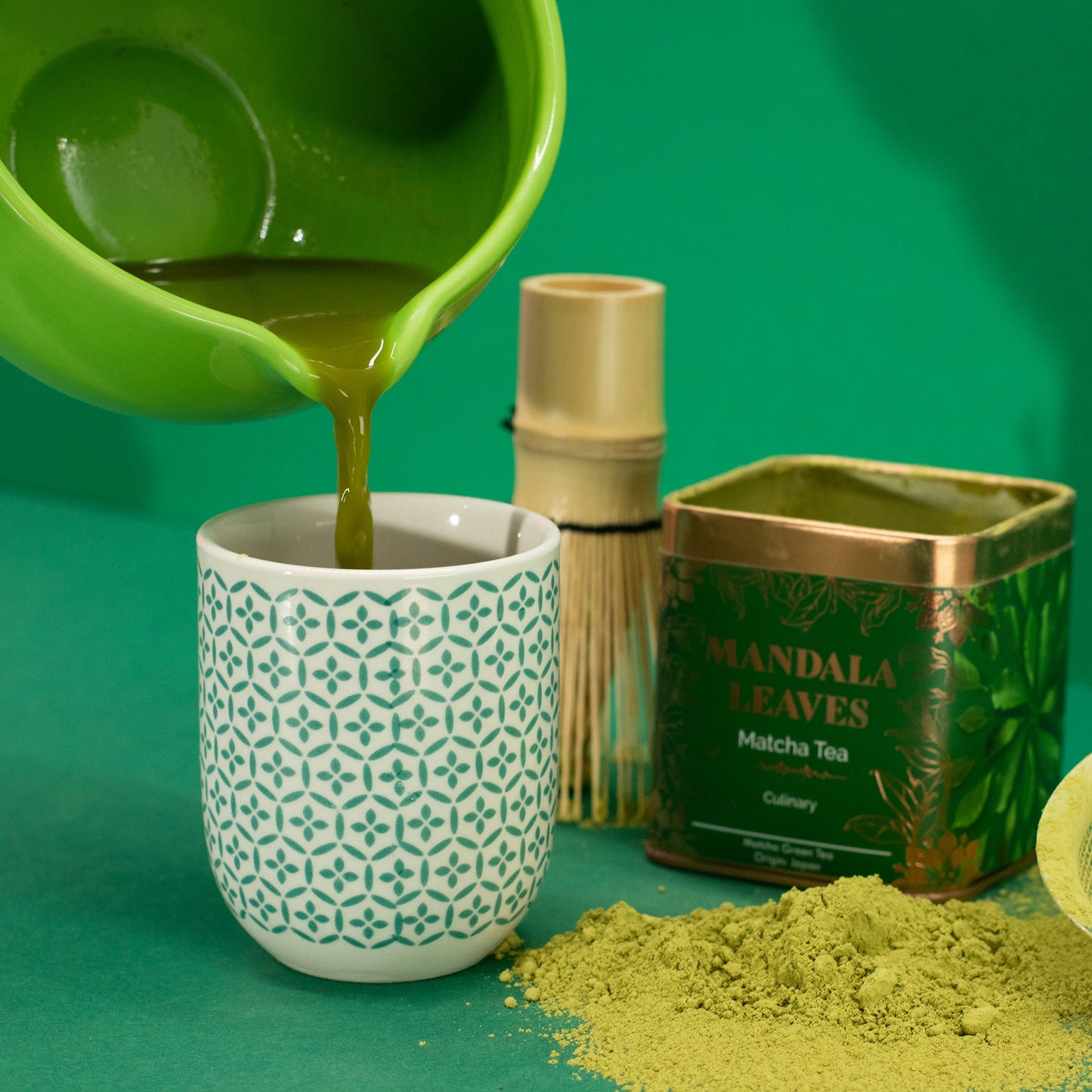 Organic Ceremonial Matcha Green Tea - Tinned - 50 g, green liquid poured into a patterned cup beside a tin and green powder by Quintessential Holistic Health Ltd