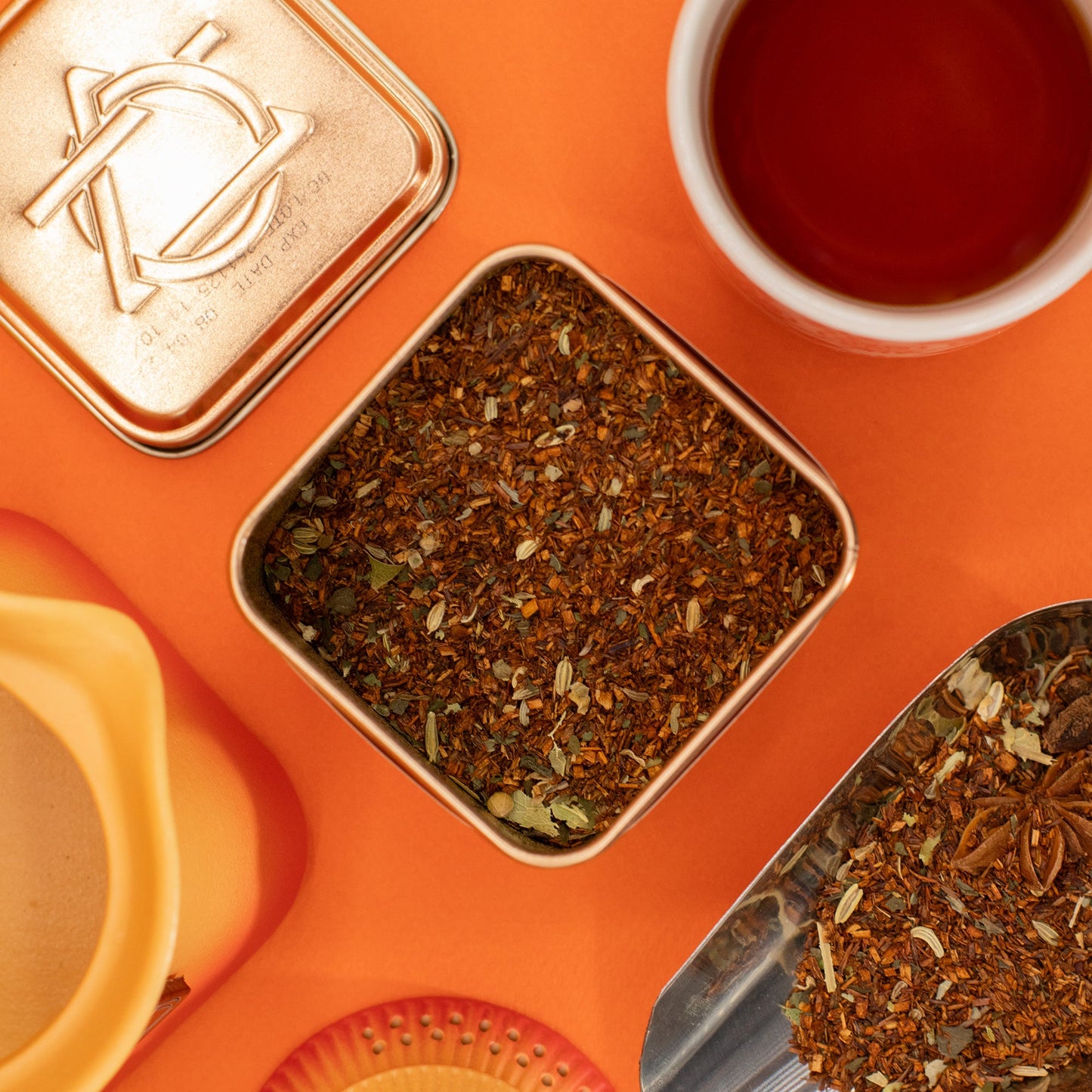 Red Bush Digestive Blend Artisan Tea - Tinned - 50g, in an open square tin beside a cup, lid and metal scoop by Quintessential Holistic Health Ltd
