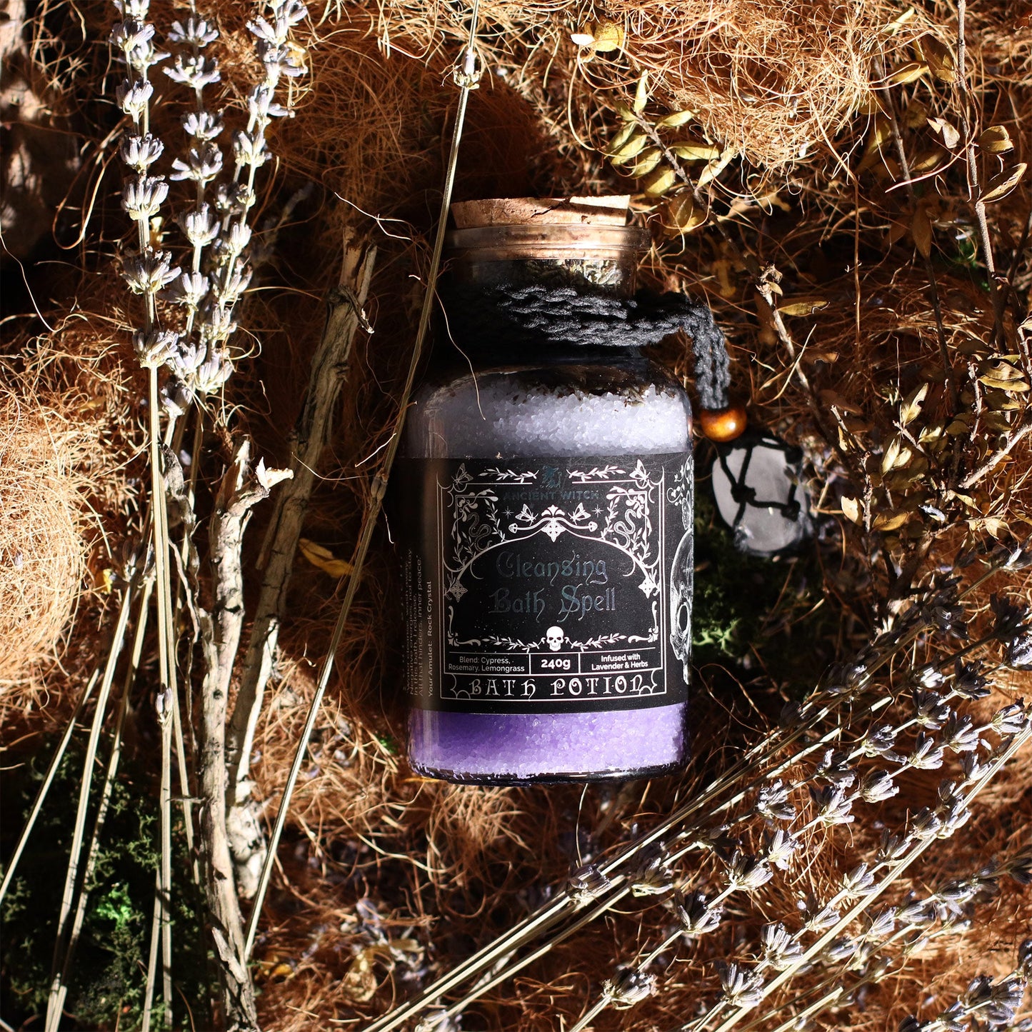 Vegan Bath Spell Potion & Rock Crystal Amulet - Cleansing, purple bottle nestled among dried grass and pale stems by Quintessential Holistic Health Ltd