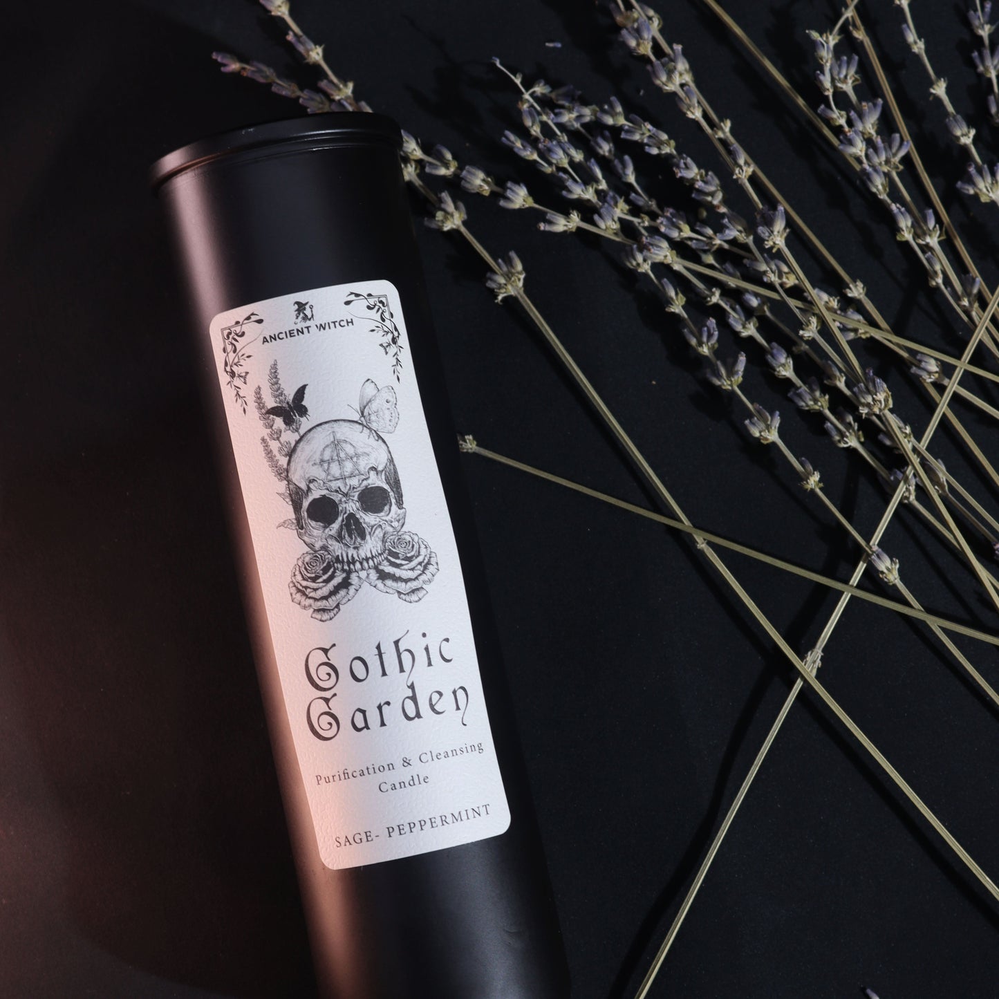 Ancient Witch Gothic Garden Ritual Candle - Cleansing & Purification as a black labelled tube beside dried flower stems by Quintessential Holistic Health Ltd