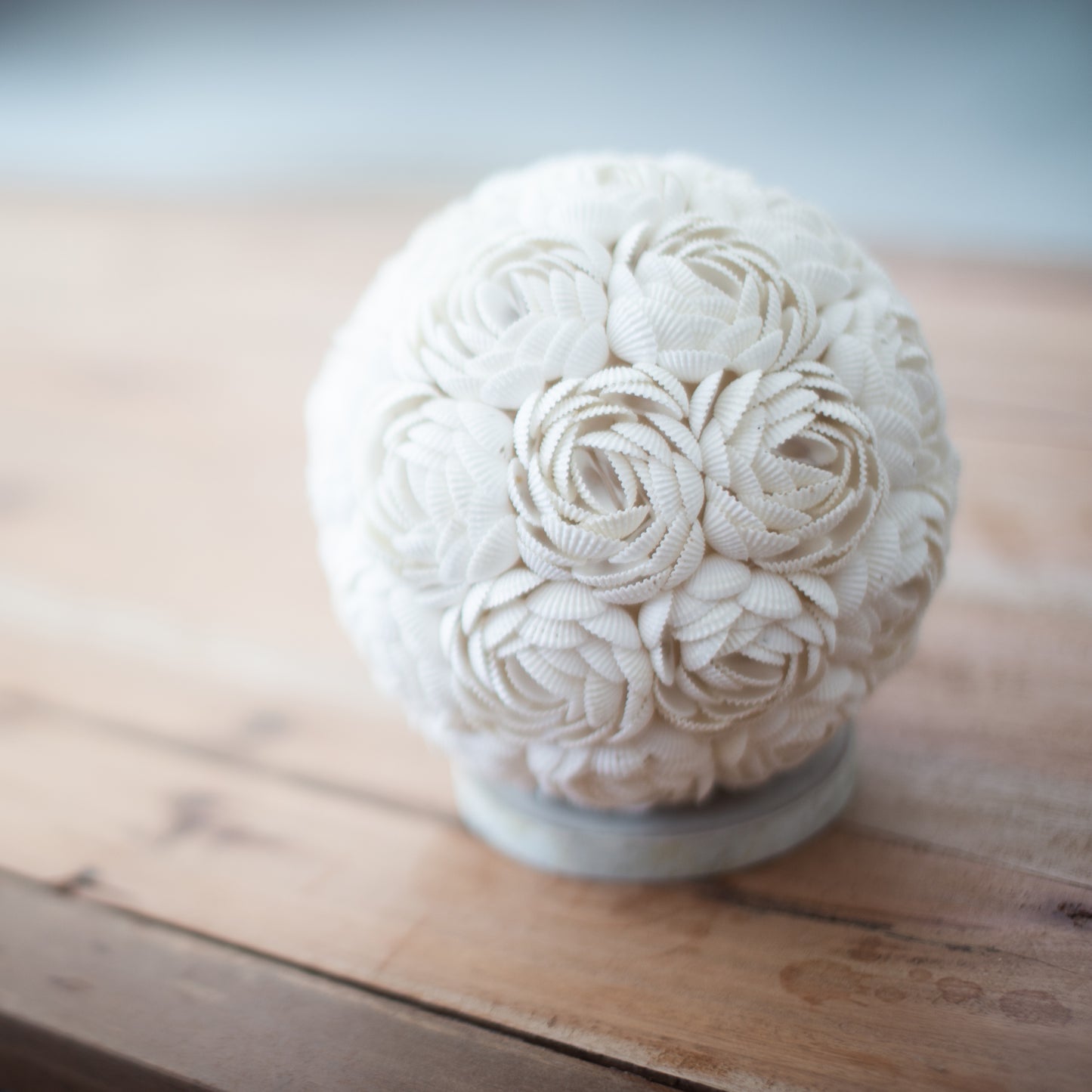 Handcrafted LED Boho Seashell Lamp - Small - Rose - Round with clustered white shell rosettes on a pale base atop a wooden surface by Quintessential Holistic Health Ltd