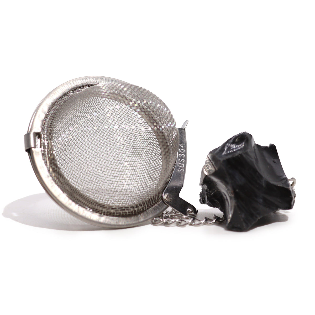 Black Obsidian Raw Gemstone Tea Strainer, Protection with an open silver mesh ball beside a rough black stone by Quintessential Holistic Health Ltd
