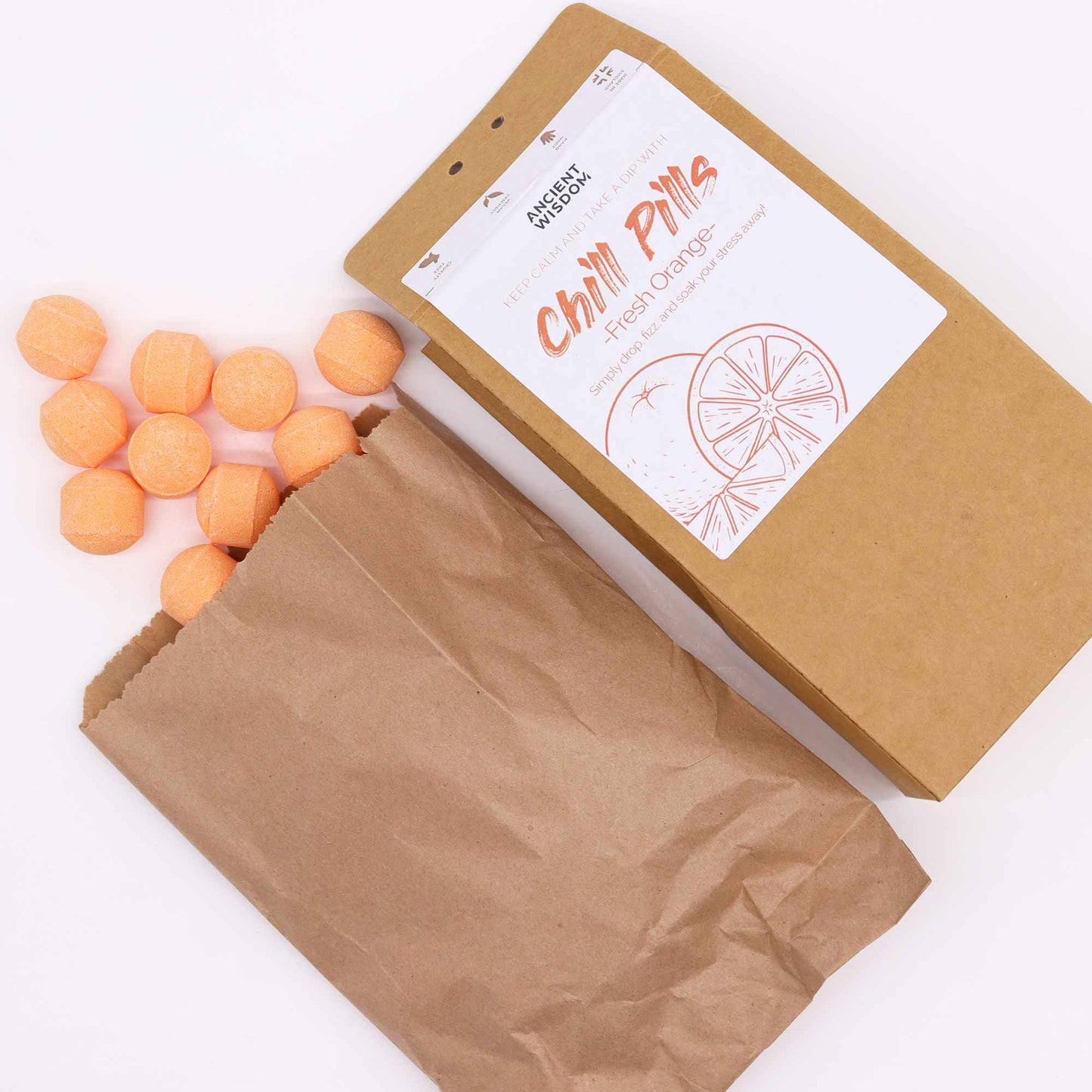 Vegan Bath Bomb Chill Pills Gift Pack - Fresh Orange - 350g, open kraft box beside a paper bag and scattered orange tablets, by Quintessential Holistic Health Ltd