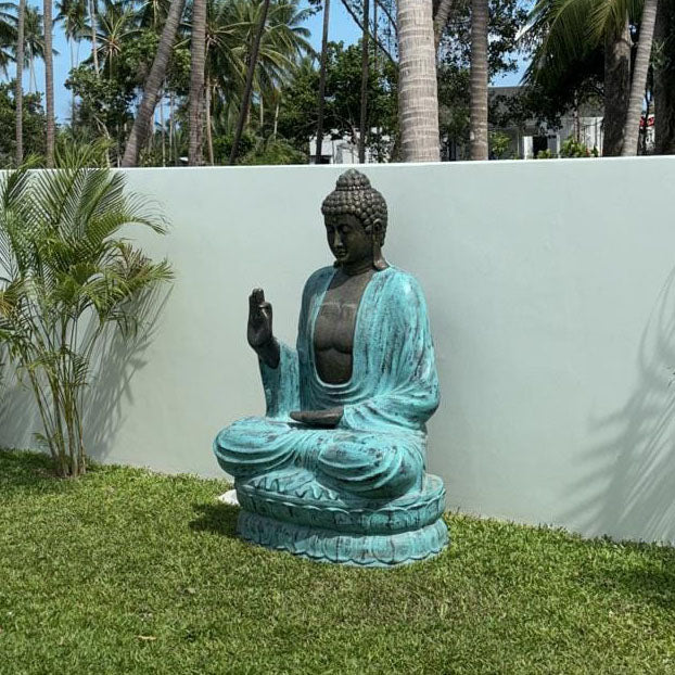 Concrete & Resin Buddha Teaching Lotus Statue - 2m Turquoise & Stone, seated Buddha with raised hand displayed on grass by Quintessential Holistic Health Ltd