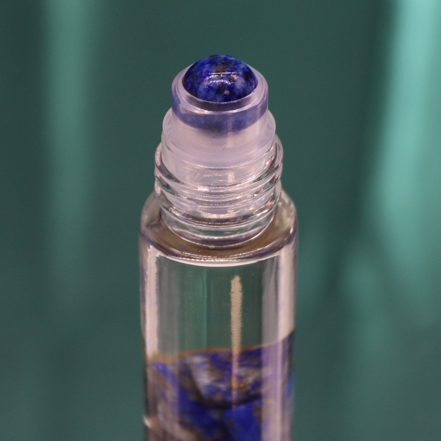 Gemstone Tarot Essential Oil Roll-On - Sodalite - The Sun showing the blue roller top above blue stones by Quintessential Holistic Health Ltd