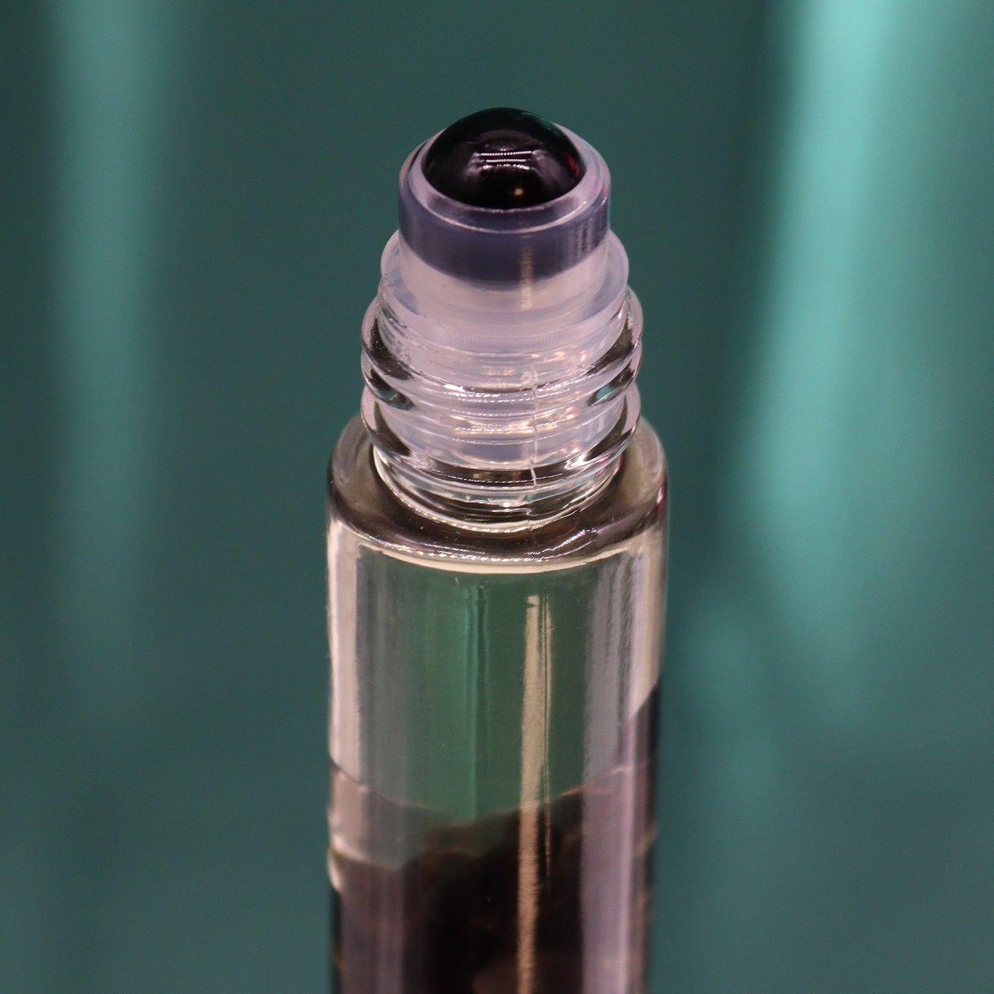 Gemstone Tarot Oil Roll-On - Black Tourmaline - Knight of Swords showing a dark roller top above black chips by Quintessential Holistic Health Ltd