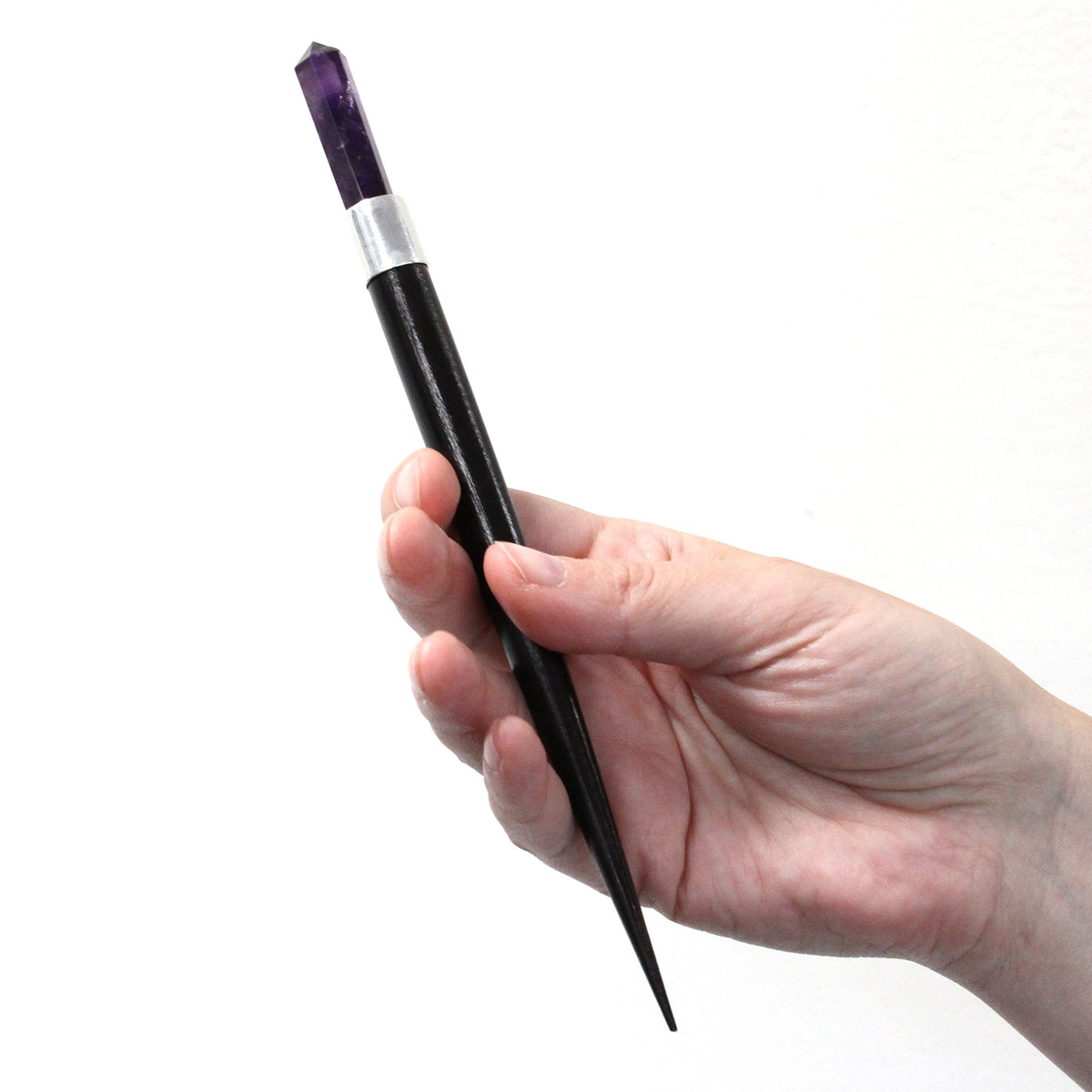 3 Handmade Healing Wands - Rock Quartz, Rose Quartz & Amethyst, a black wand with a purple tip held upright in one hand by Quintessential Holistic Health Ltd