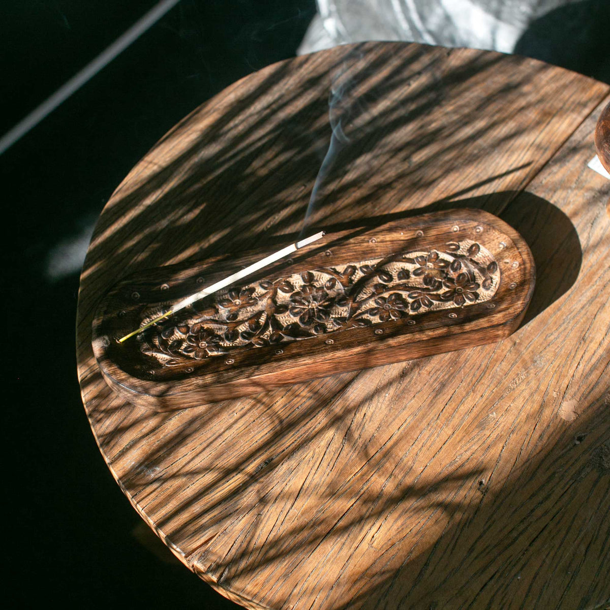 Mango Wood Dual Incense Tray - Flower Design, with an ornate carved floral panel, incense stick and rising smoke by Quintessential Holistic Health Ltd