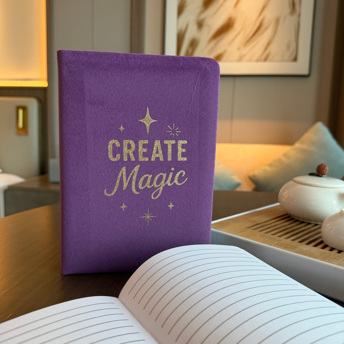 Velvet Journal - A5 - Purple - Create Magic standing upright beside an open lined journal, with lettering and stars visible by Quintessential Holistic Health Ltd