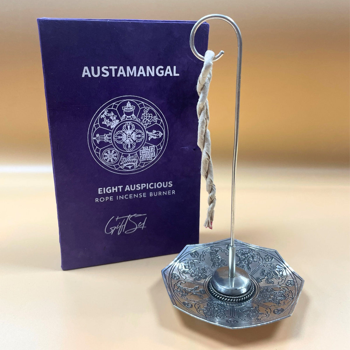 Rope Incense and Silver Plated Holder Set - Astamangal with twisted rope hanging above a patterned octagonal holder and purple cover by Quintessential Holistic Health Ltd