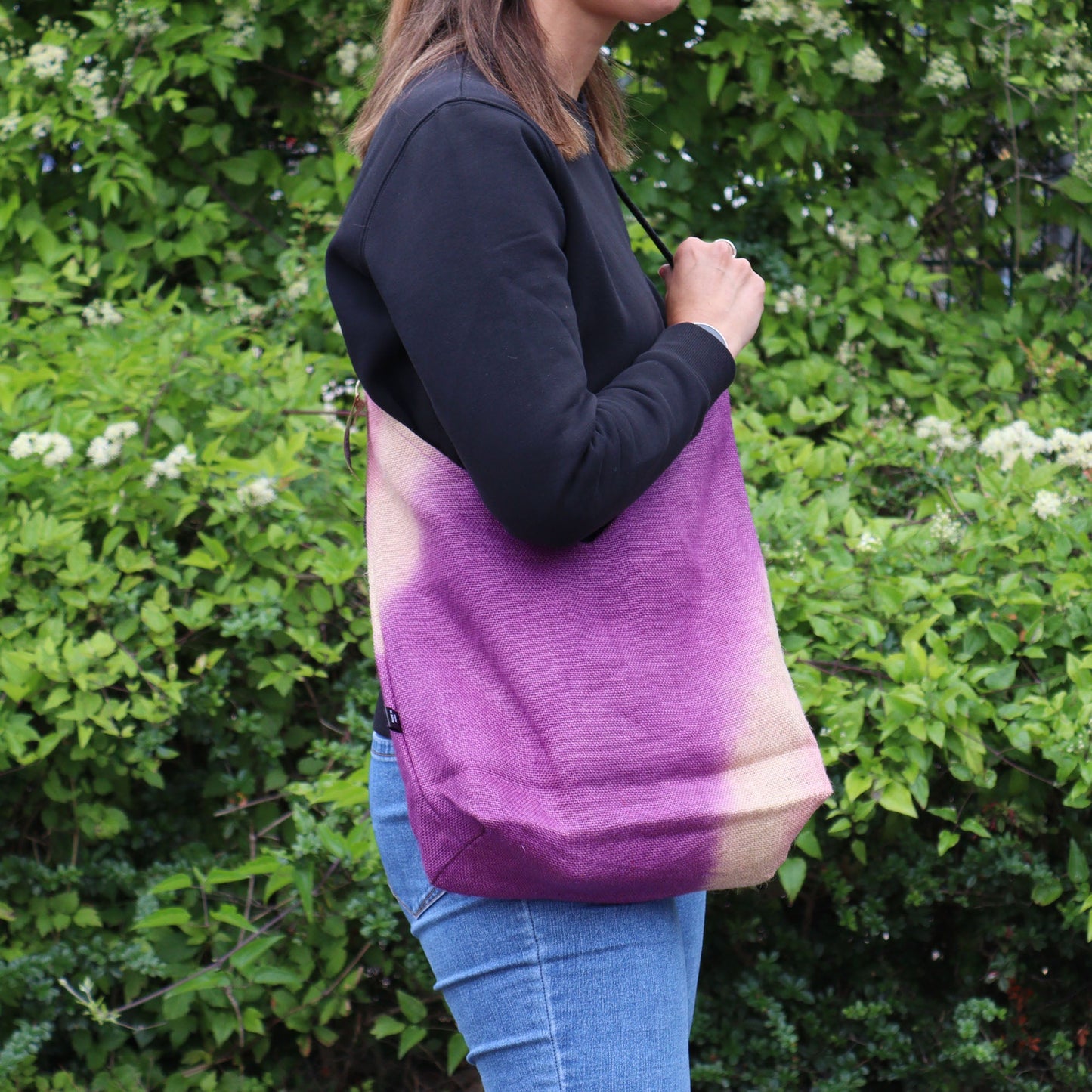 Jute and Cotton Shoulder Tote Bag - Fuchsia worn at the side with a black top and blue jeans by Quintessential Holistic Health Ltd