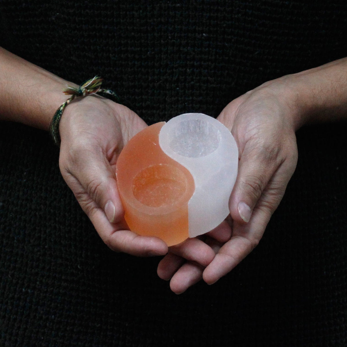 Selenite Yin Yang Candle Holder with separate orange and white halves held in two hands by Quintessential Holistic Health Ltd