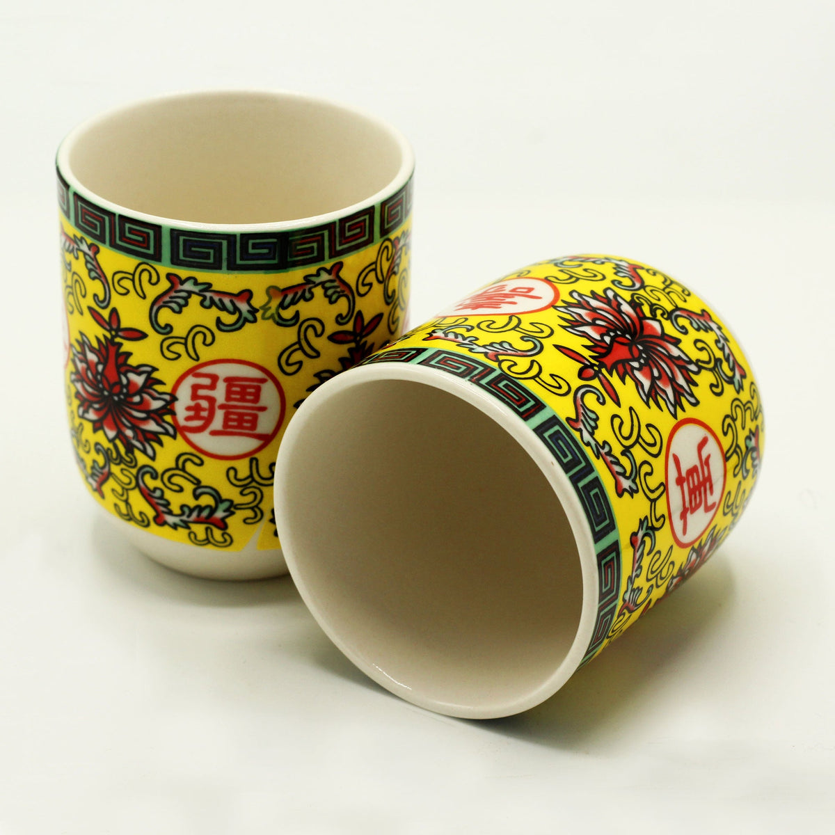 Ceramic Long Life Yellow Oriental Design Herbal Tea Cups - 6 Pack shown as one upright cup and one on its side with multicoloured motifs by Quintessential Holistic Health Ltd