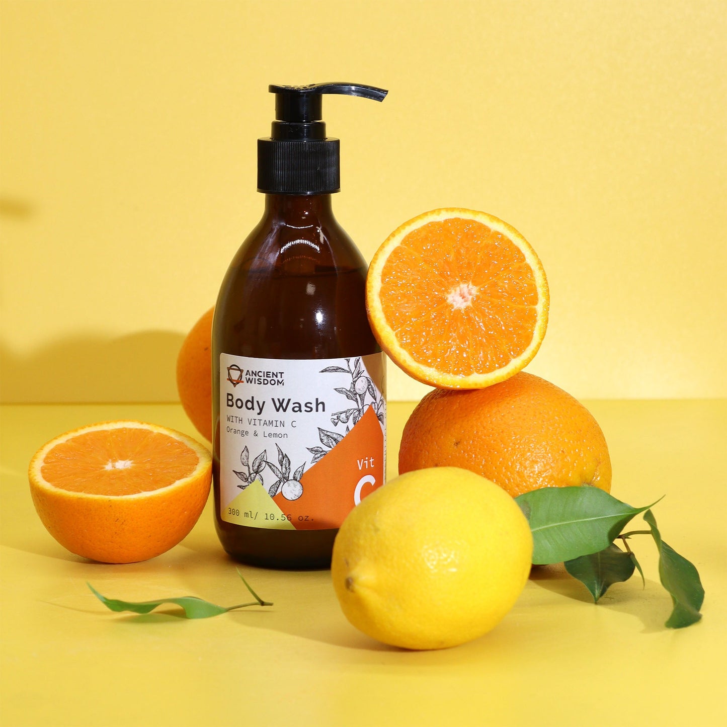 Vitamin C Aromatherapy Body Wash - Orange & Lemon - 300ml, amber pump bottle arranged with oranges and a lemon by Quintessential Holistic Health Ltd