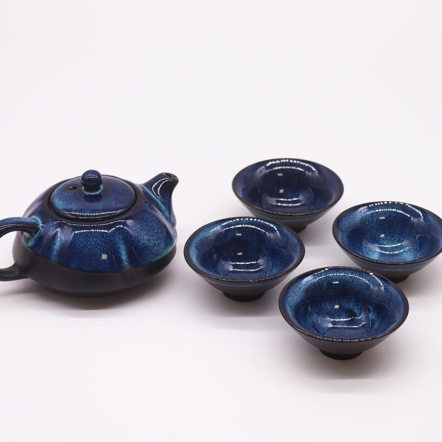 200ml Blue Glazed Ceramic Teapot Pouring Tea into a Matching Cup with no Background