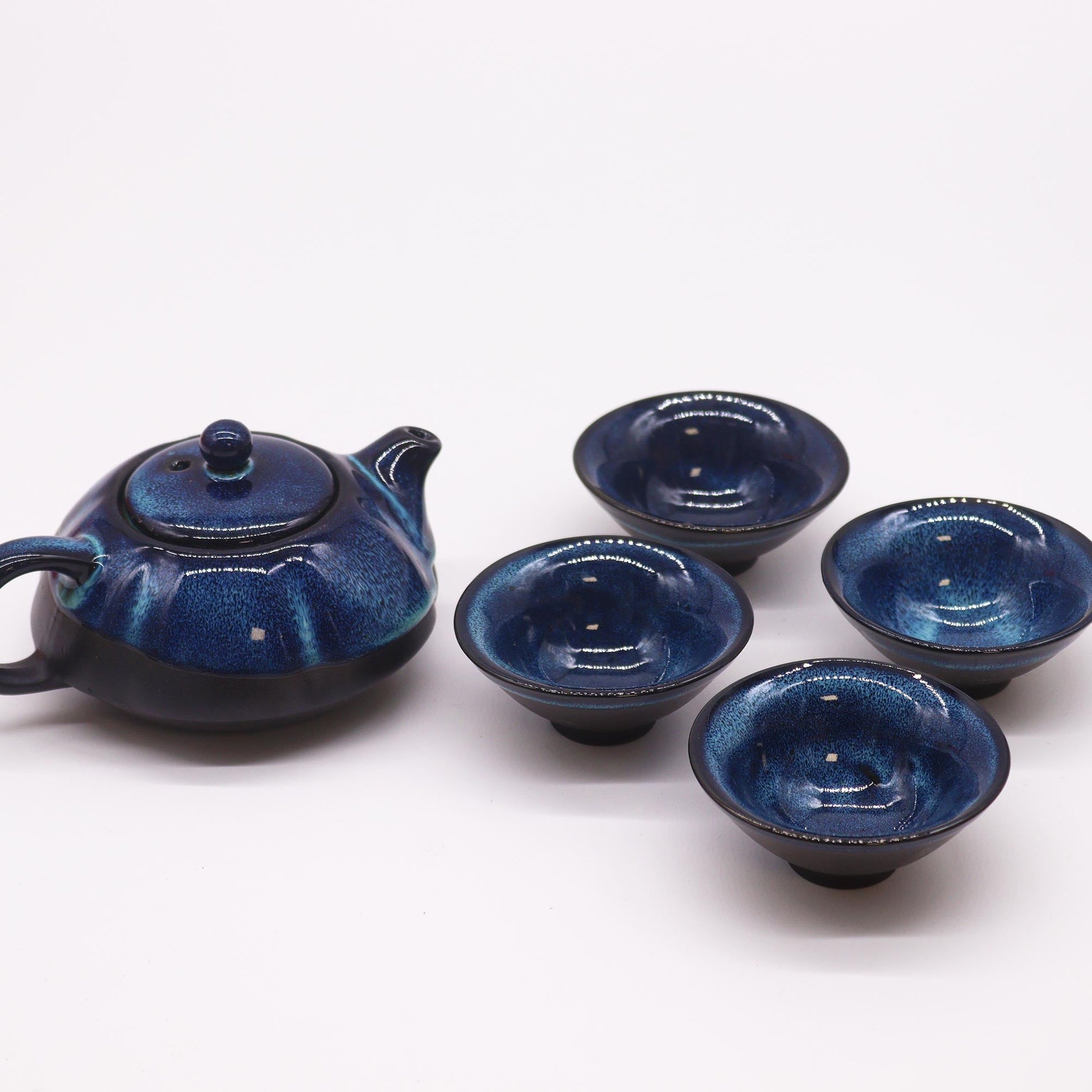 200ml Blue Glazed Ceramic Teapot Pouring Tea into a Matching Cup with no Background