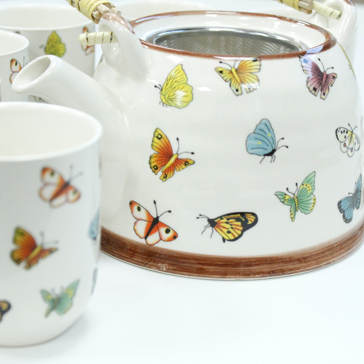 Side View of the 650ml Butterflies Design White Glazed Herbal Teapot with Strainer and a Matching Cup