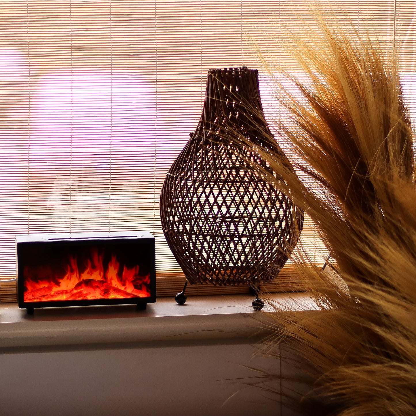 Colour-Change USB Aroma Diffuser – Black Flame Effect & Bird Sound, glowing orange and red beside a woven lamp and dried grasses by Quintessential Holistic Health Ltd