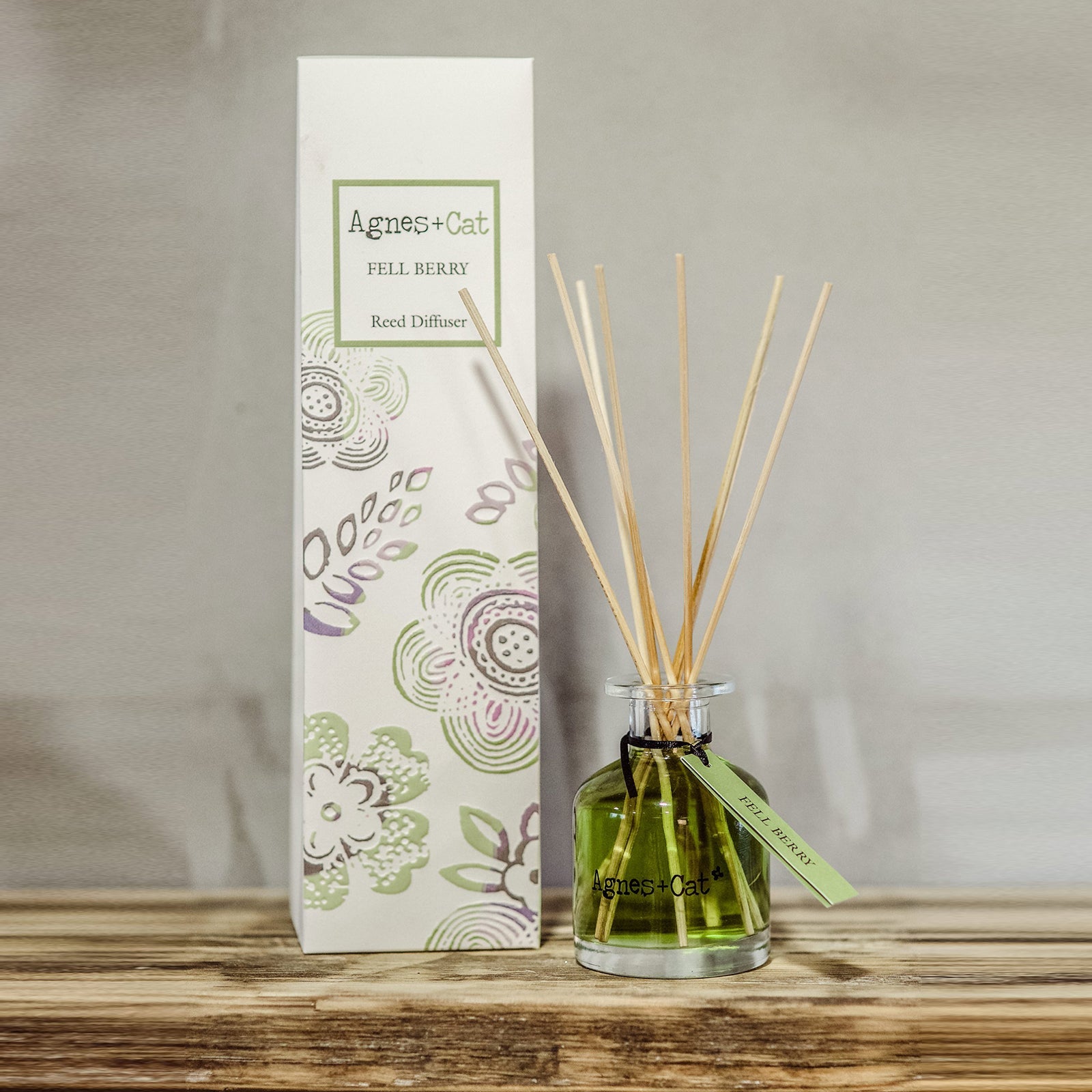 Reed Diffuser - Fell Berry - 140ml, green bottle with natural-coloured reeds in front of a tall illustrated box by Quintessential Holistic Health Ltd