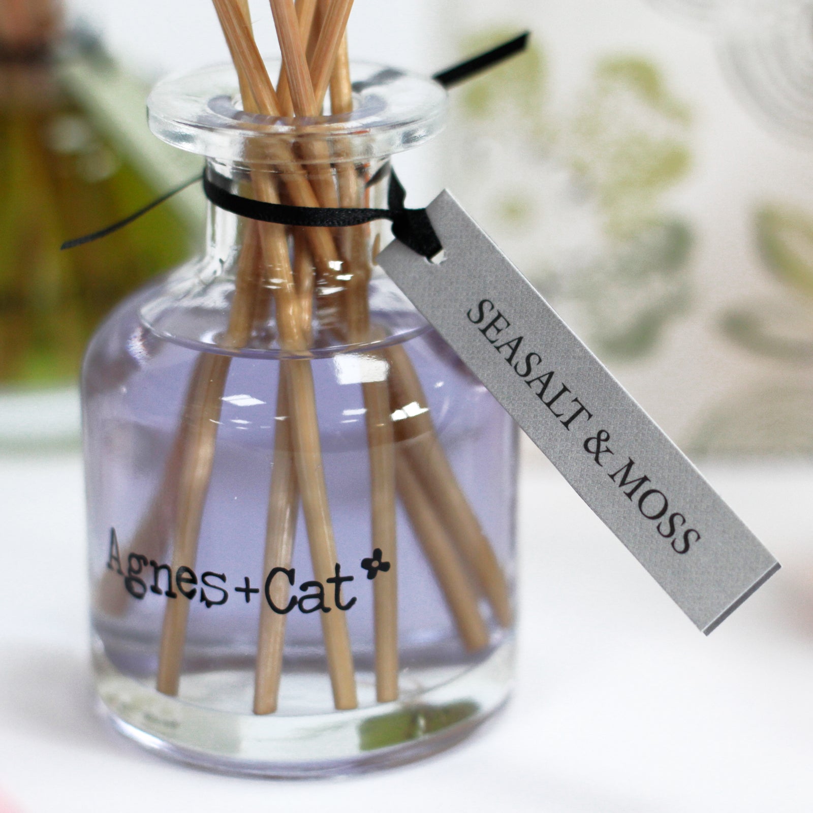 Reed Diffuser - Sea Salt and Moss - 140ml, close-up of a pale purple bottle with natural-coloured reeds and a grey name tag, by Quintessential Holistic Health Ltd