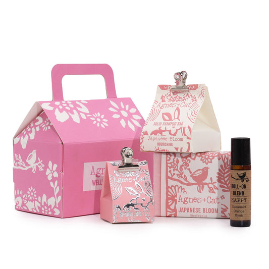Handmade Personal Wellness Gift Set - Bloom and Bliss, pink floral box displayed with two patterned cartons and a small dark bottle, by Quintessential Holistic Health Ltd