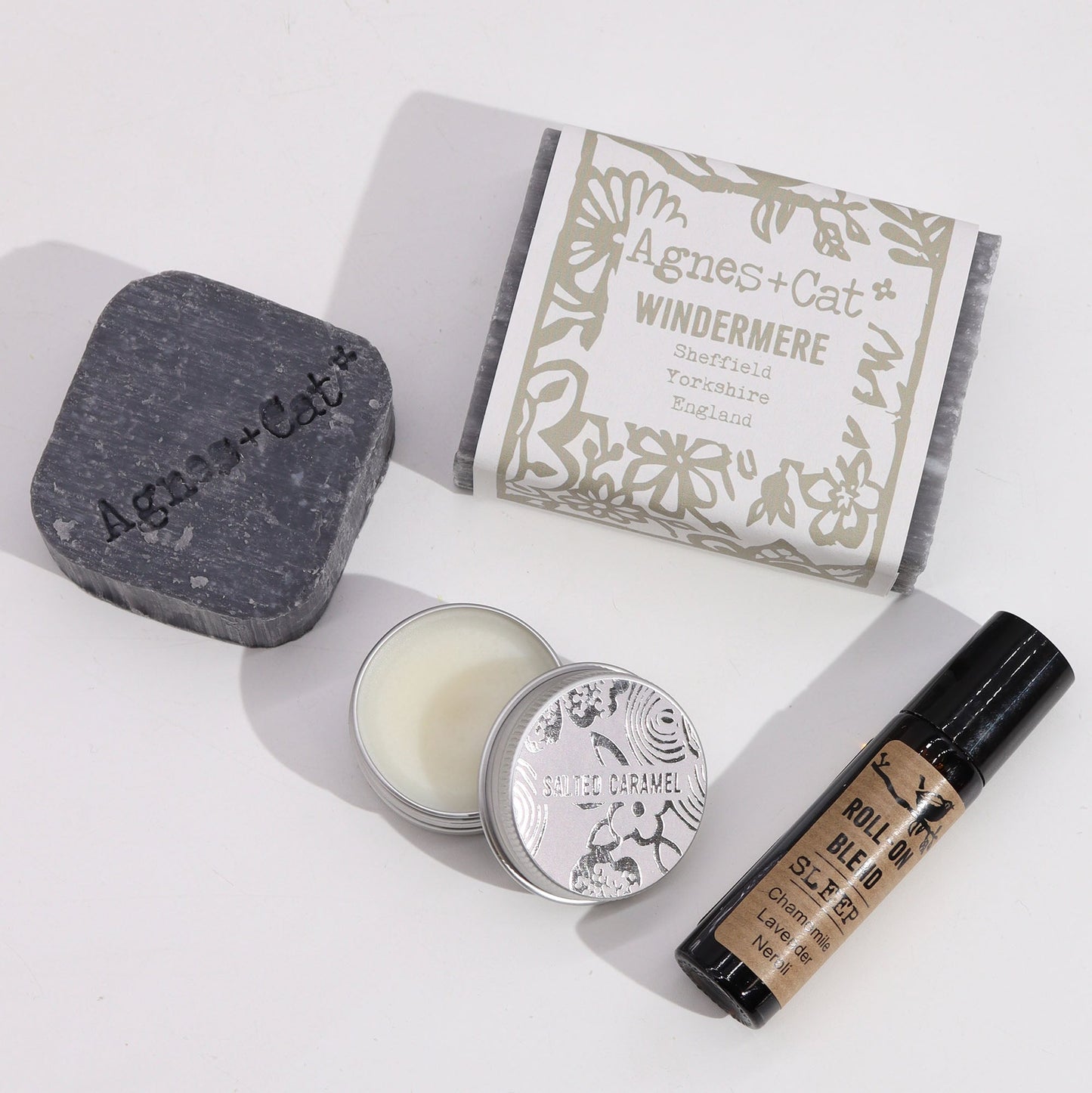 Handmade Personal Wellness Gift Set - Lake Breeze, dark grey soap beside a boxed bar, an open round tin and a small dark bottle, by Quintessential Holistic Health Ltd