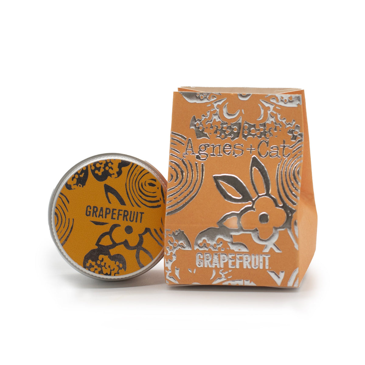 Hand-Poured Vegan-Friendly Natural Lip Balm - Grapefruit, with an orange illustrated tin beside a matching box, by Quintessential Holistic Health Ltd