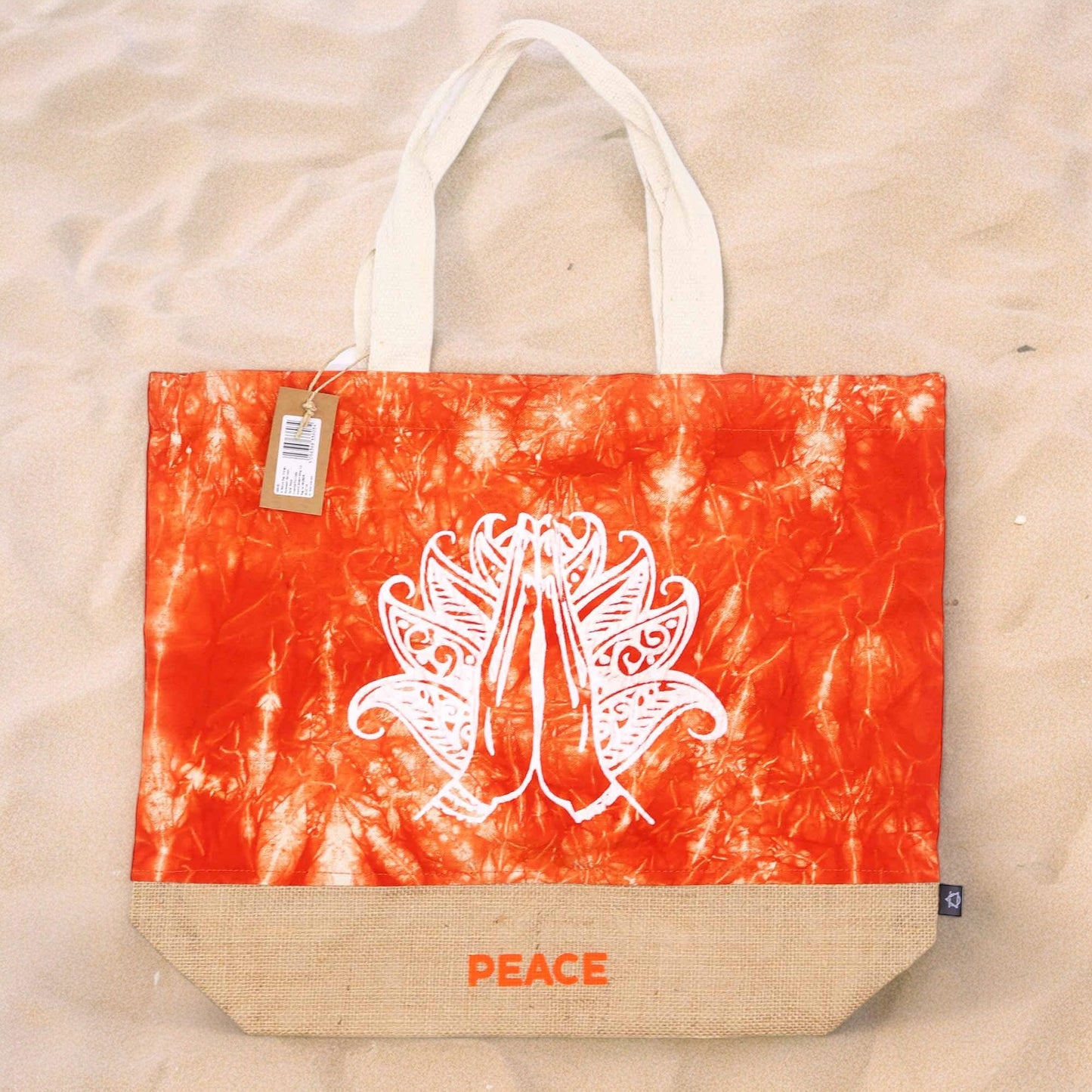 Orange Stonewash Jute & Cotton Tote Bag - Namaste Hand - Peace standing on a pale textured surface with its white hand design visible by Quintessential Holistic Health Ltd