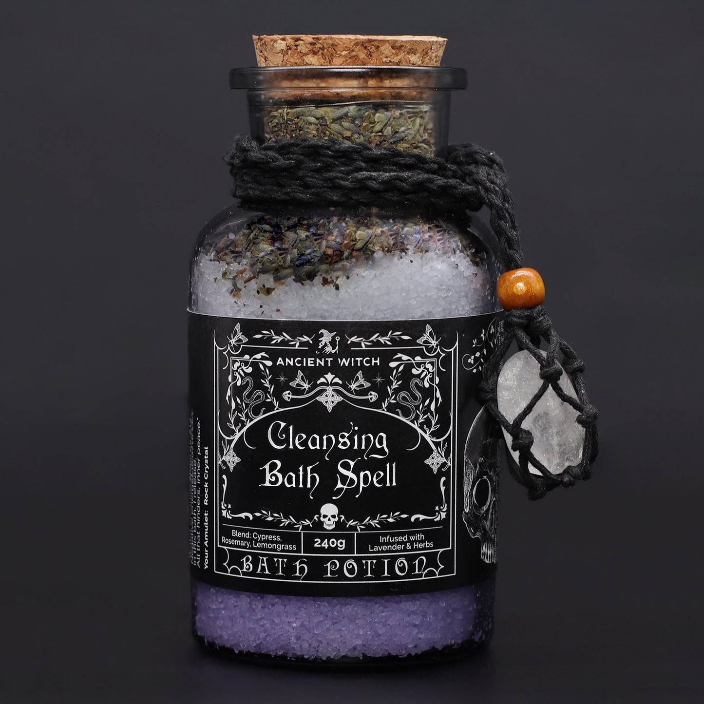 Vegan Bath Spell Potion & Rock Crystal Amulet - Cleansing, corked purple bottle with black cord and pale charm on a dark background by Quintessential Holistic Health Ltd