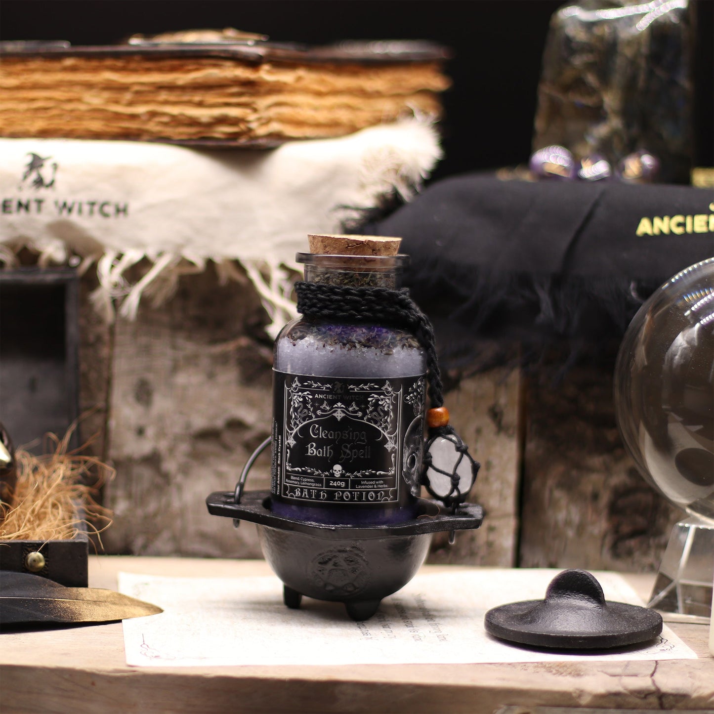 Vegan Bath Spell Potion & Rock Crystal Amulet - Cleansing, corked purple bottle displayed upright in a small black cauldron by Quintessential Holistic Health Ltd