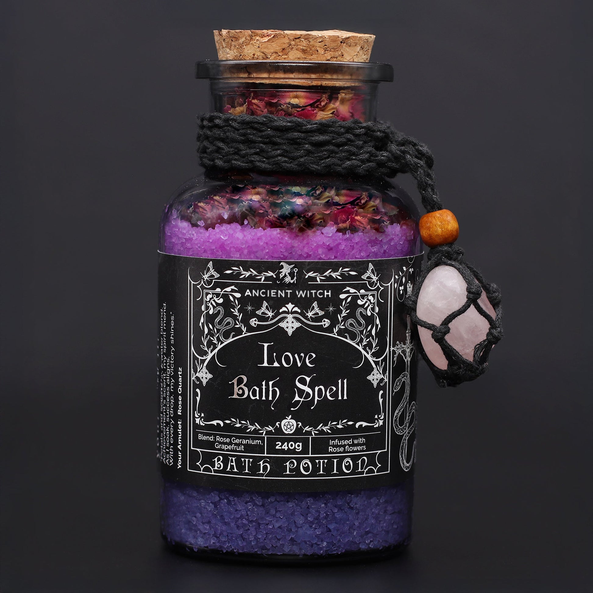Vegan Bath Spell Potion & Rose Quartz Crystal Amulet - Love, corked purple bottle with black cord and pink charm on a dark background by Quintessential Holistic Health Ltd