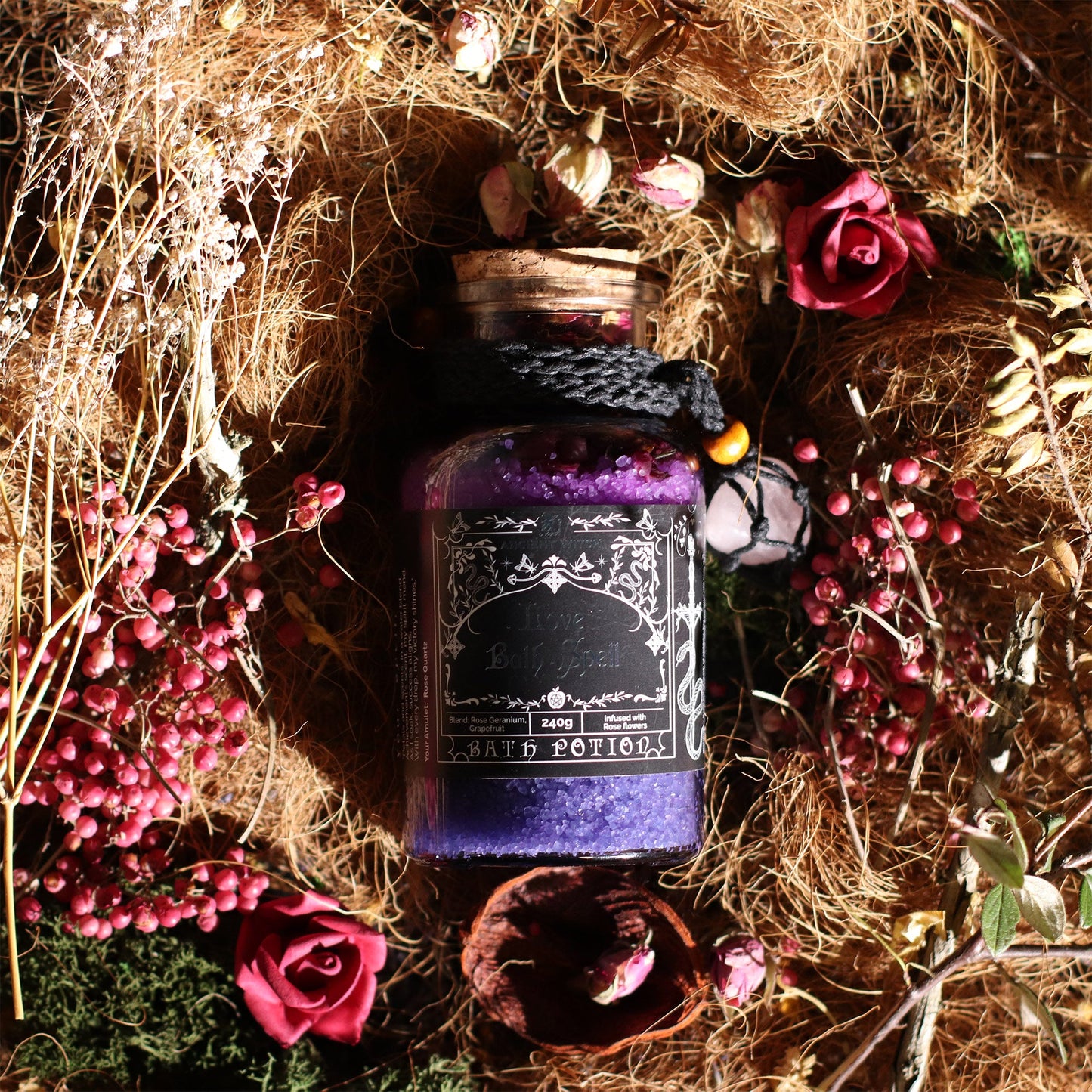 Vegan Bath Spell Potion & Rose Quartz Crystal Amulet - Love, purple bottle arranged among dried grass, red roses and pink flowers by Quintessential Holistic Health Ltd