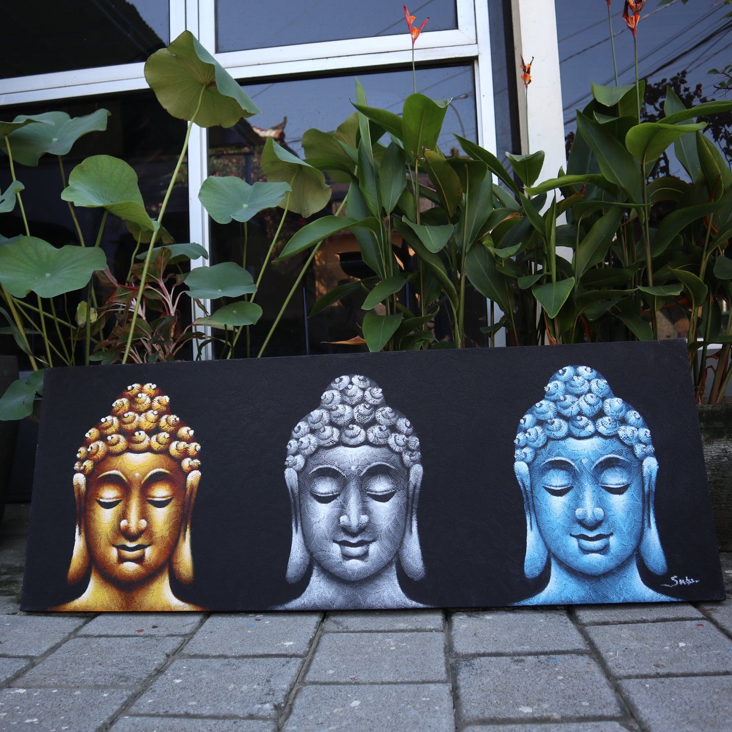 Hand Painted Buddha Painting - Black - Three Heads, gold, silver and blue Buddha heads displayed outdoors by Quintessential Holistic Health Ltd