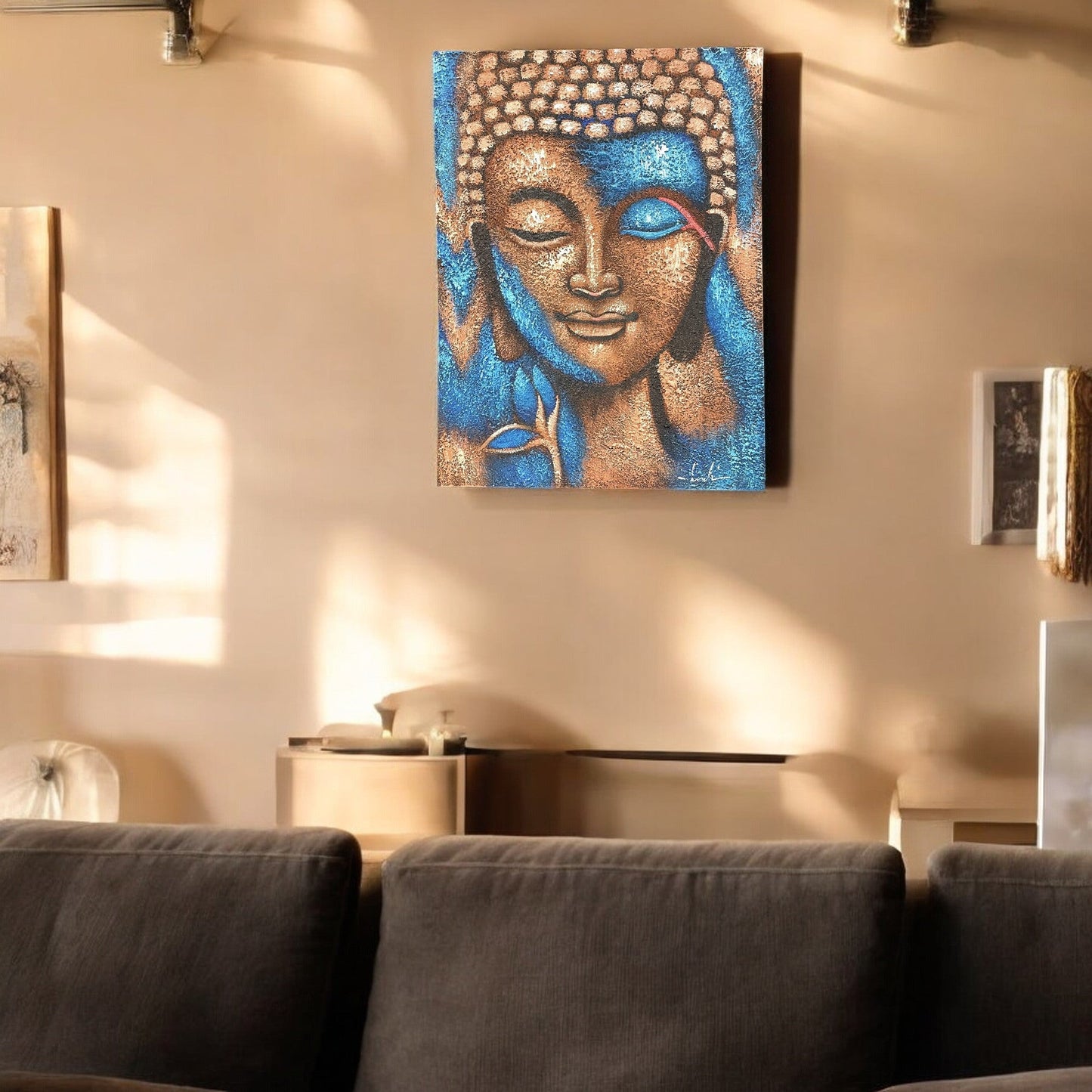 Hand-Painted Buddha Painting - Bronze and Blue Flower, displayed on a pale wall above a dark sofa in a softly lit room, by Quintessential Holistic Health Ltd