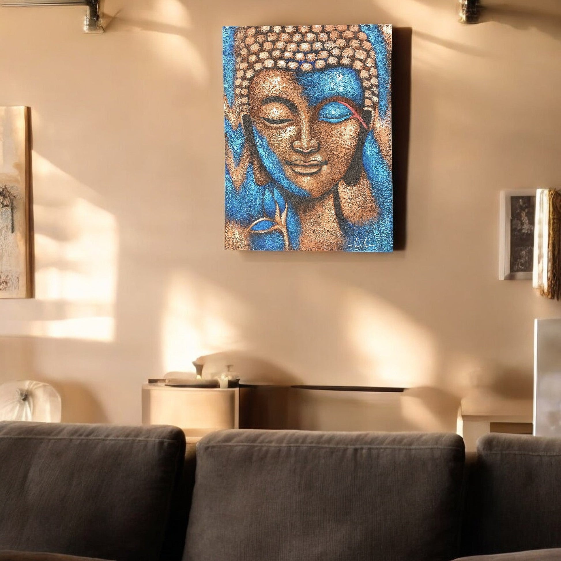 Hand-Painted Buddha Painting - Bronze and Blue Flower, displayed on a pale wall above a dark sofa in a softly lit room, by Quintessential Holistic Health Ltd