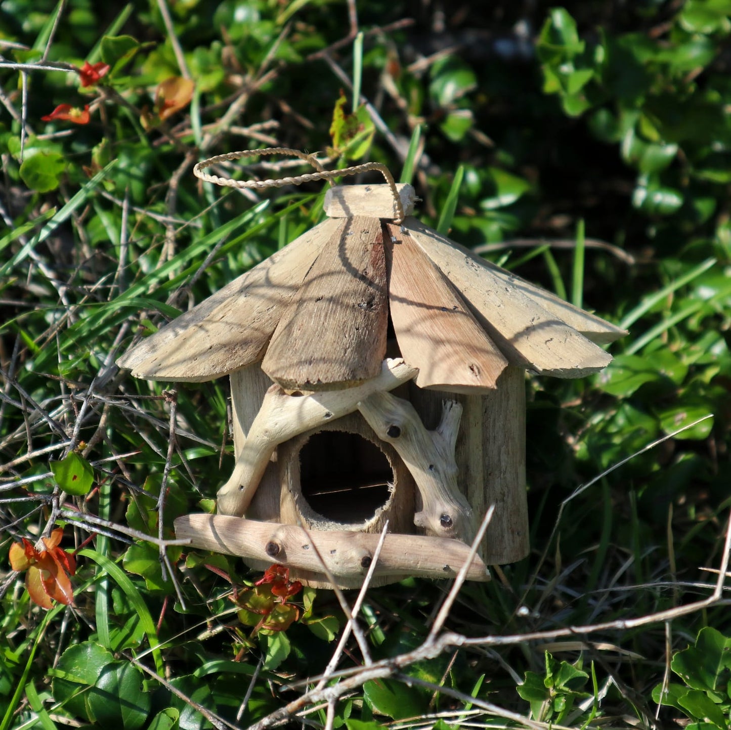 Handmade Recycled Driftwood Bird Box - Small, hanging outdoors with a round entrance, layered roof and twig-framed front, by Quintessential Holistic Health Ltd