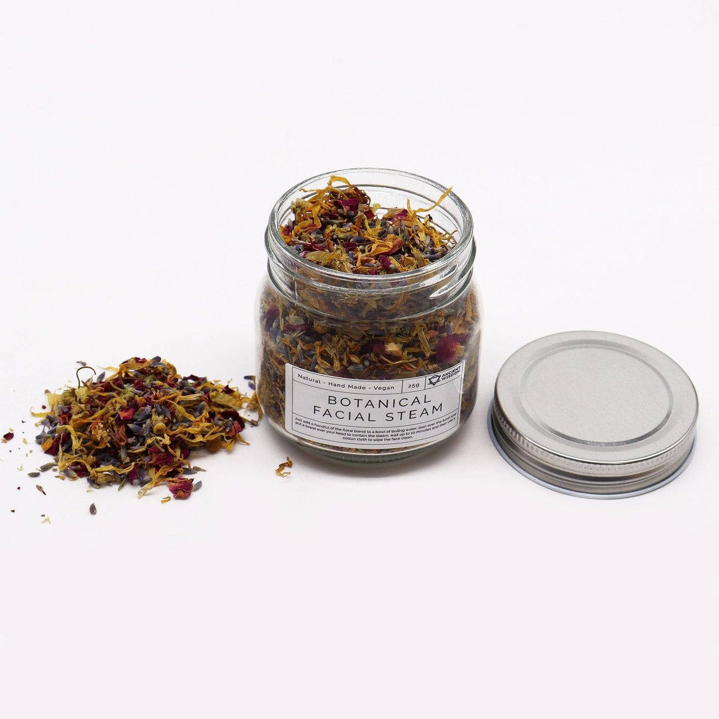 Natural Botanical Blend Facial Steam - 250g in an open labelled glass jar beside its silver lid and scattered dried flower pieces by Quintessential Holistic Health Ltd