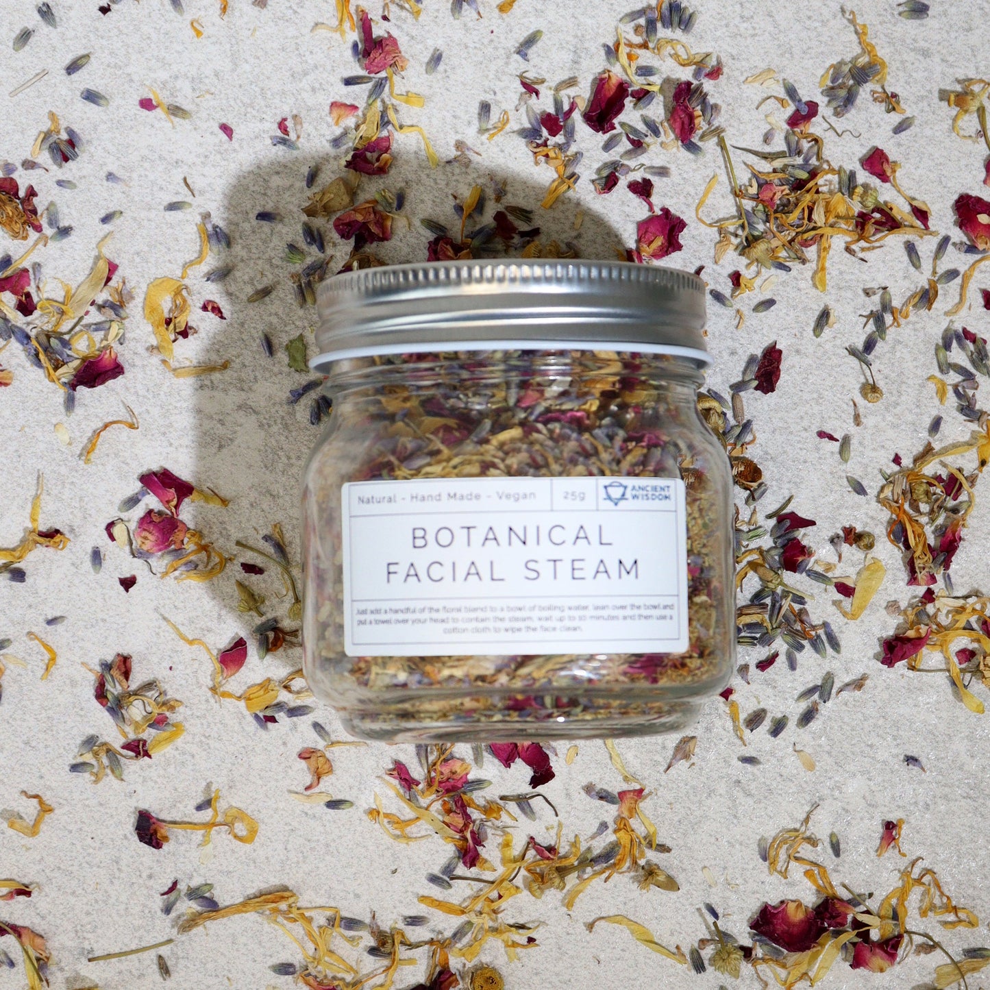 Natural Floral Bath Soak - 140g, labelled glass jar with a silver lid amid scattered colourful dried botanicals, by Quintessential Holistic Health Ltd