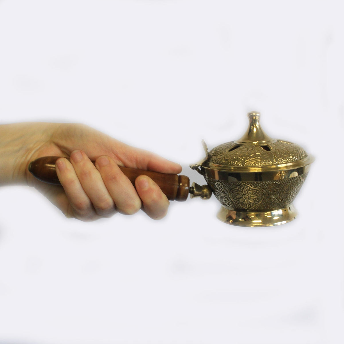 Small Ornate Brass Incense Burner with Handle with a pierced domed lid and engraved bowl held in a hand by Quintessential Holistic Health Ltd