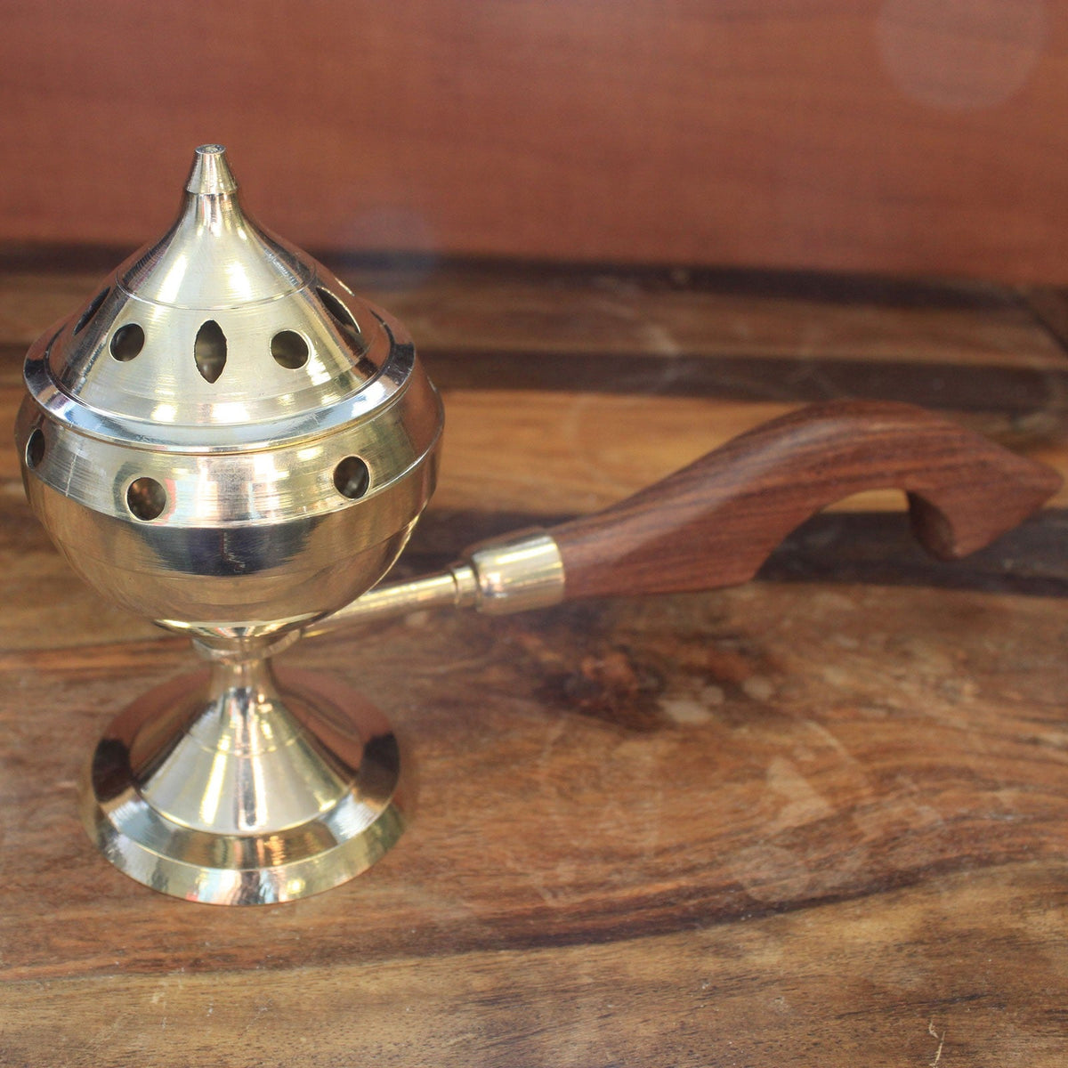 Small Plain Brass Incense Burner with Handle, standing with a silver-toned pointed perforated lid and curved wooden grip by Quintessential Holistic Health Ltd