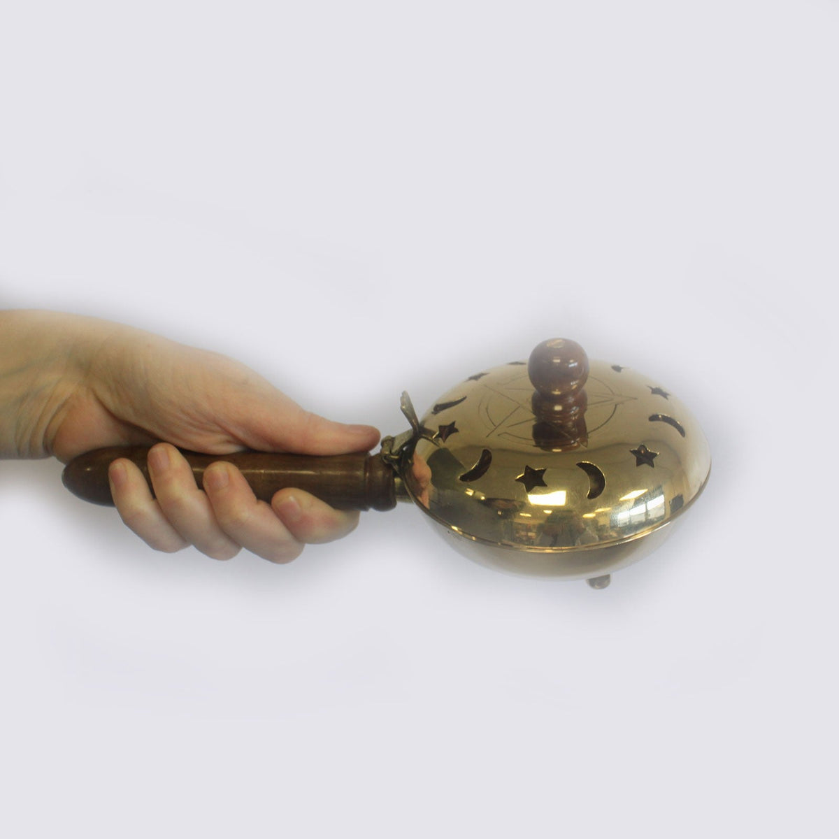 Large Pentagram Brass Incense Burner with Handle, shown held in one hand with its pierced domed lid and wooden grip visible, by Quintessential Holistic Health Ltd