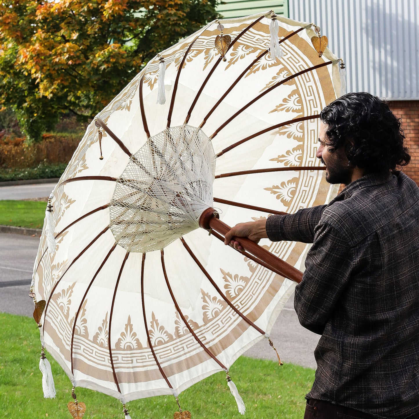Handcrafted Decorative Parasol - Medium - Natural with cream canopy, brown ribs, painted border and white tassels, held open by Quintessential Holistic Health Ltd