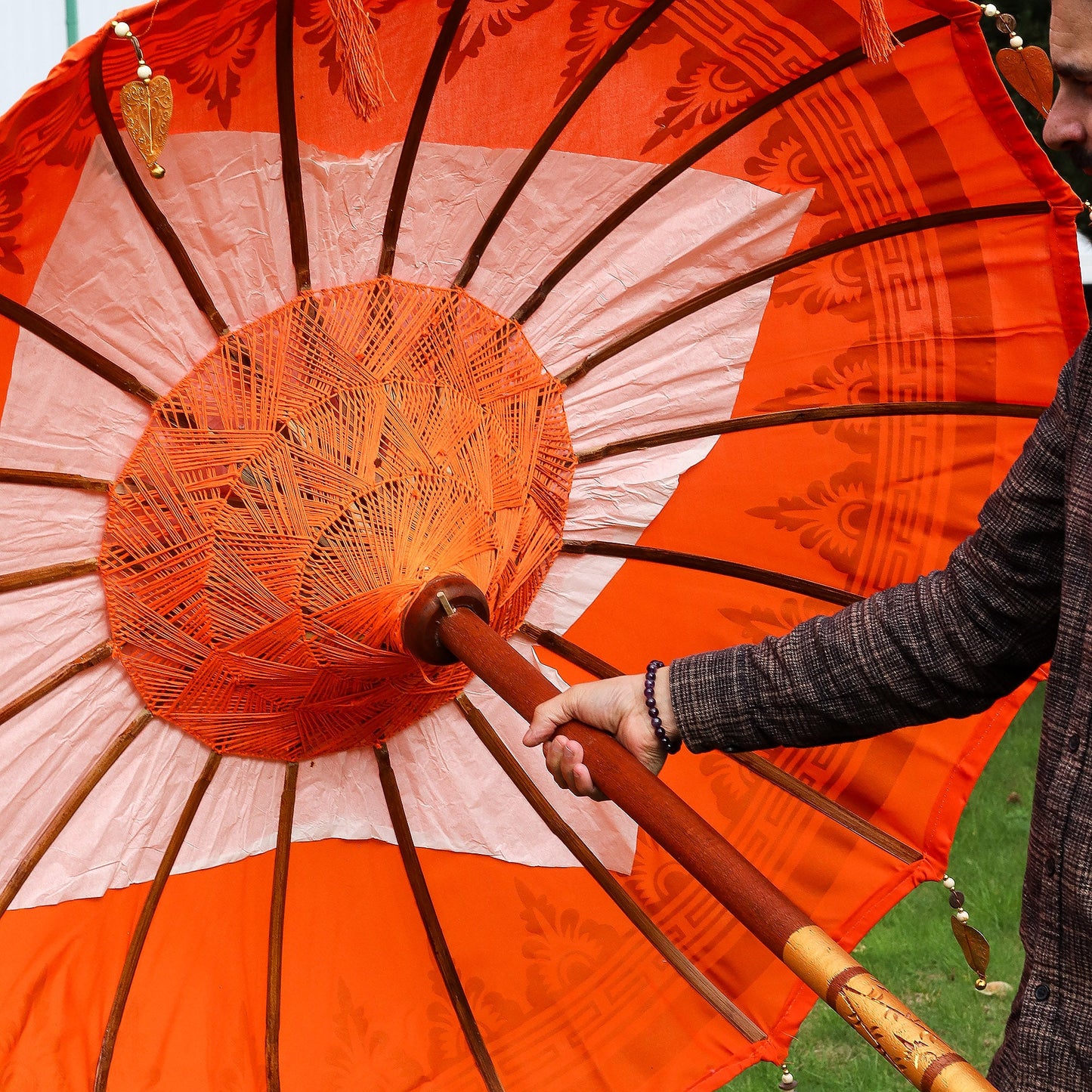 Handcrafted Decorative Parasol - Medium - Orange Decor showing dark radial ribs, central woven hub and orange pole by Quintessential Holistic Health Ltd