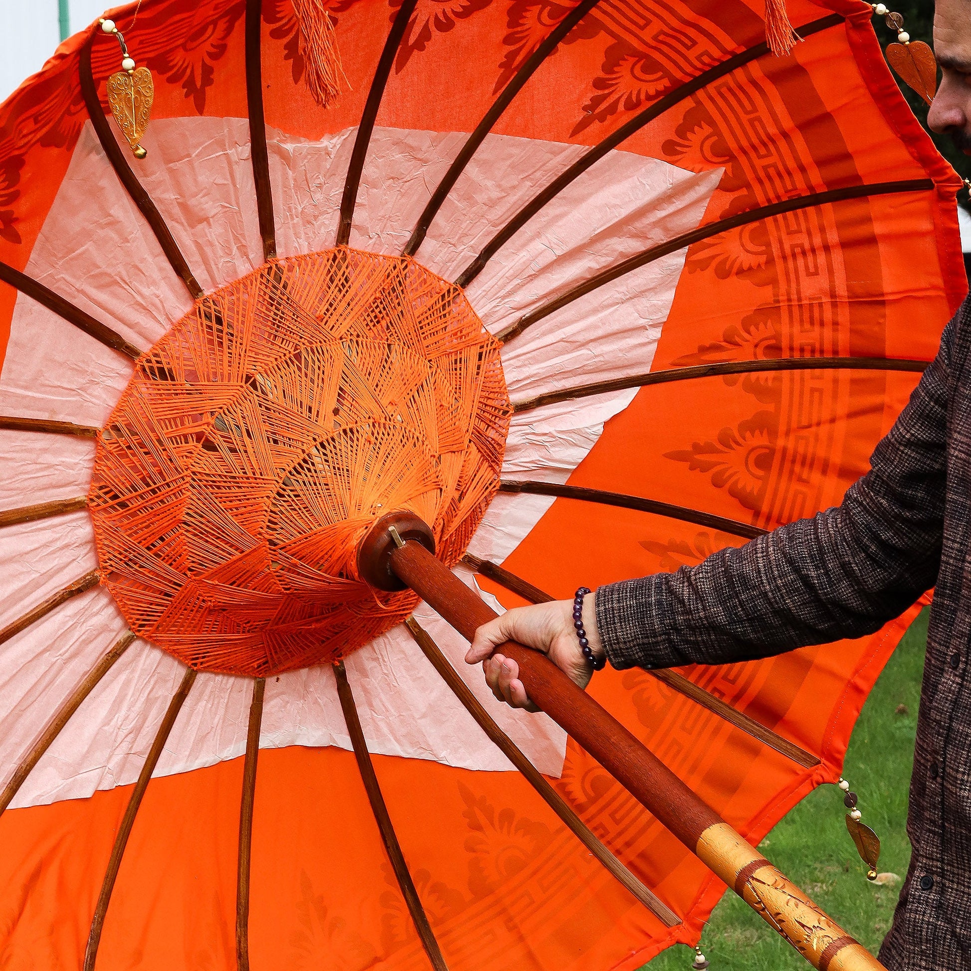 Handcrafted Decorative Parasol - Medium - Orange Decor showing dark radial ribs, central woven hub and orange pole by Quintessential Holistic Health Ltd