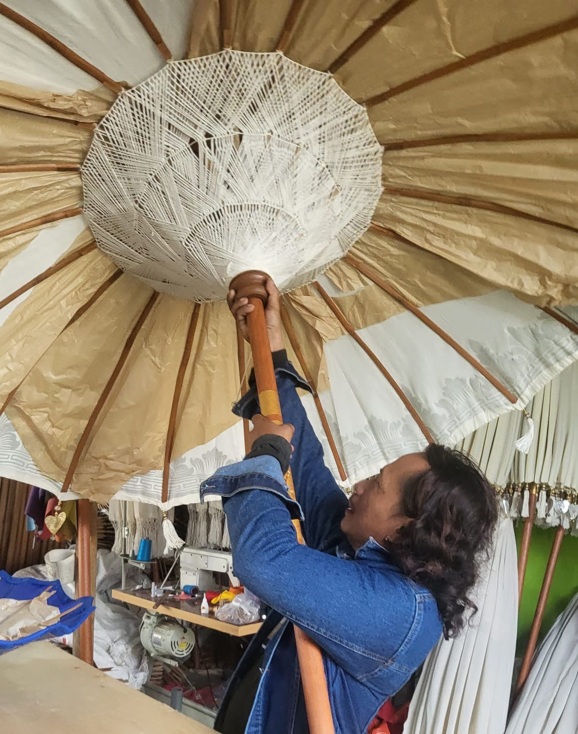Handcrafted Decorative Parasol - Large - Turquoise showing cream canopy lining and large white woven centre, held overhead by Quintessential Holistic Health Ltd