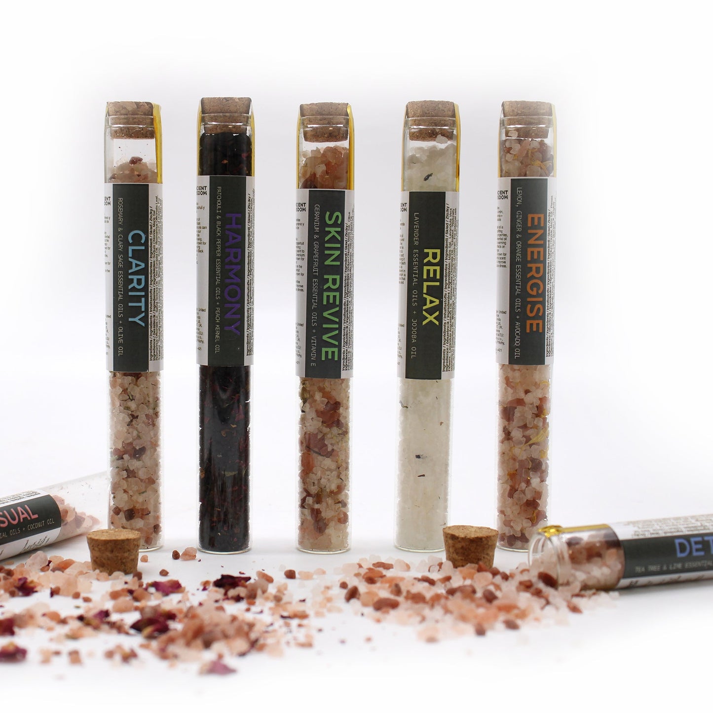 Gift Set of 7 Essential Oil Bath Salts in Vials, with five upright labelled vials and two lying among loose salts, by Quintessential Holistic Health Ltd