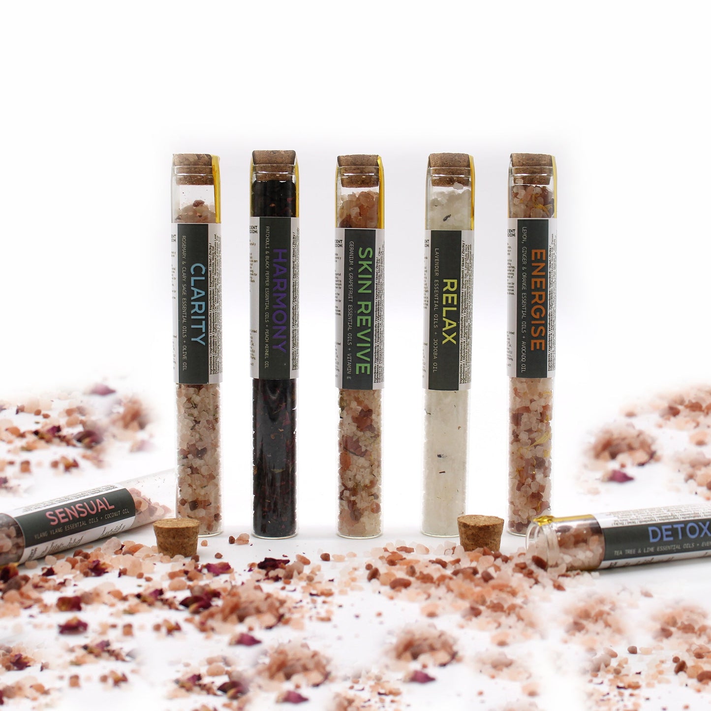 Gift Set of 7 Essential Oil Bath Salts in Vials, with five upright vials and two lying across scattered salts, by Quintessential Holistic Health Ltd