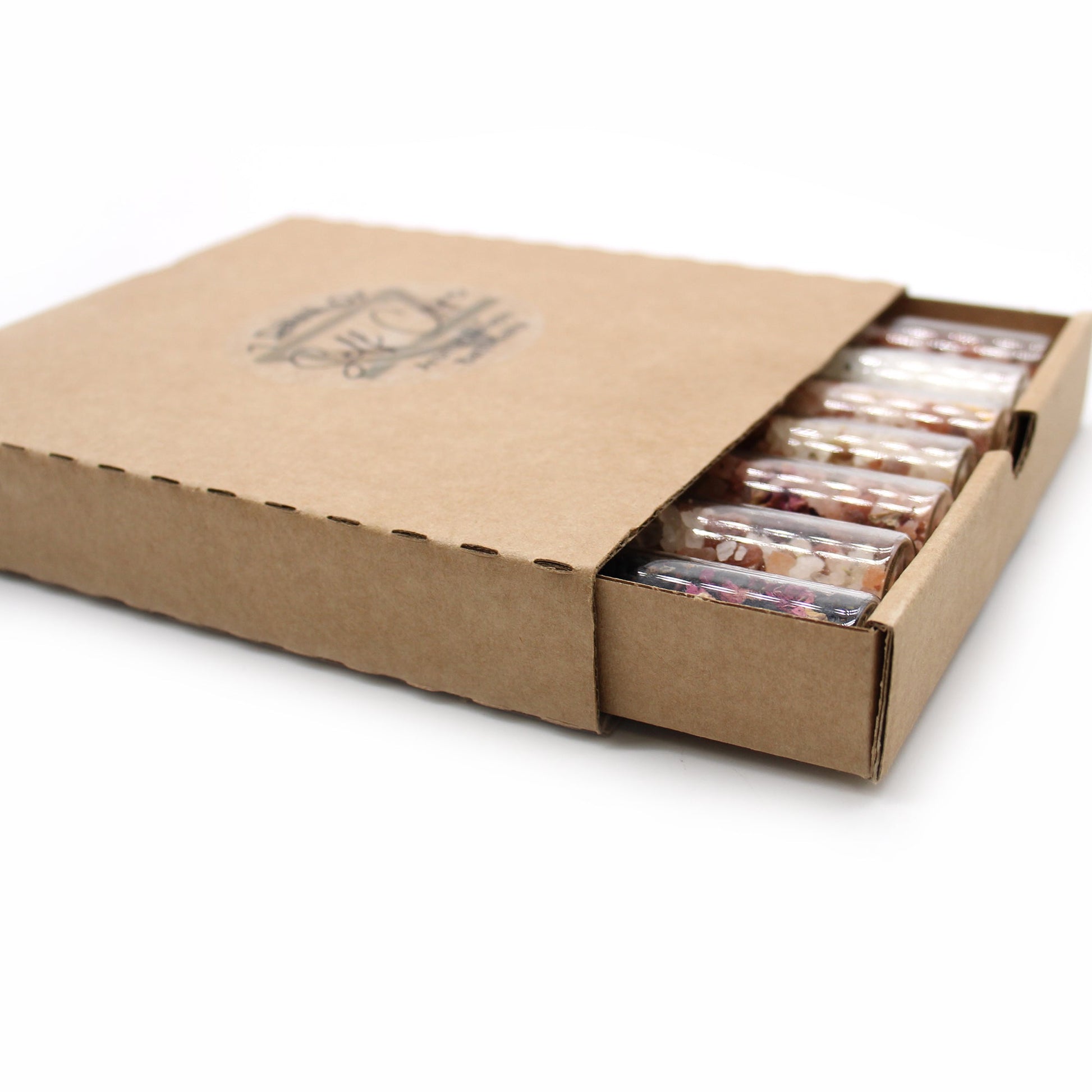 Gift Set of 7 Essential Oil Bath Salts in Vials, visible inside an open rectangular cardboard box, by Quintessential Holistic Health Ltd